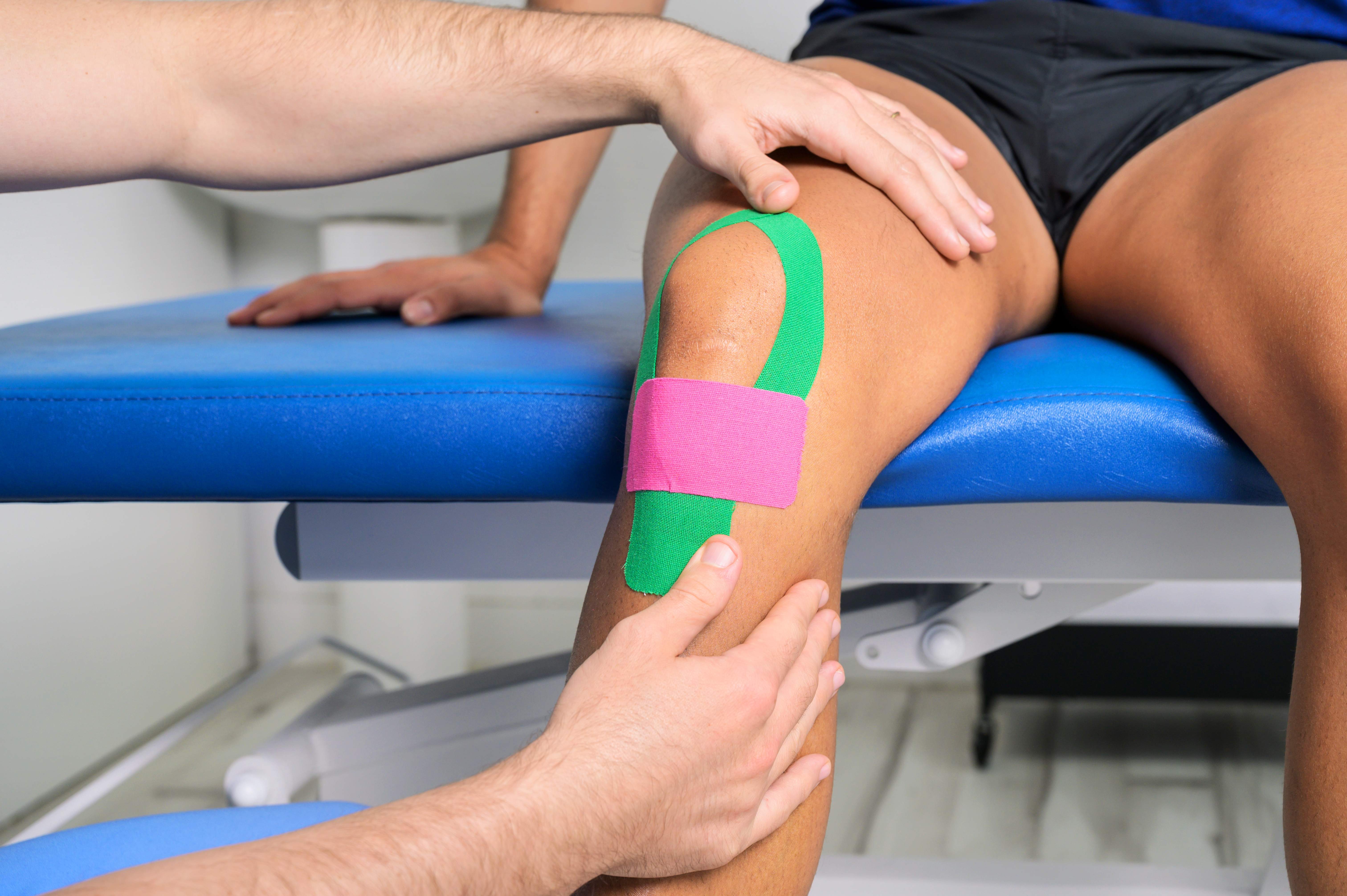 physical therapist applying kinesio tape on male p 0921ca002fb2b3ffea91