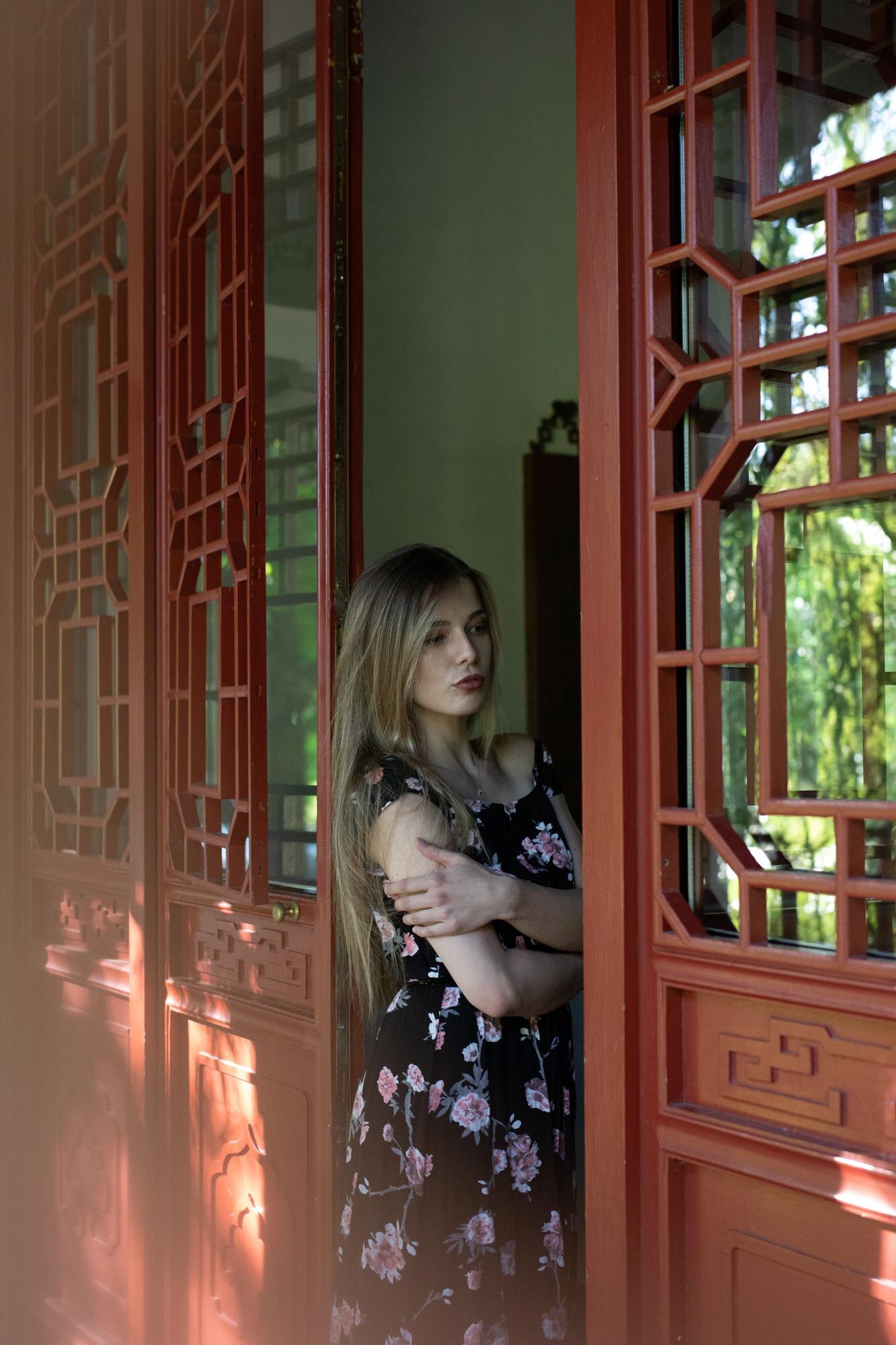portrait of woman standing against window at home 1c2c1a1d3433fd74bba7
