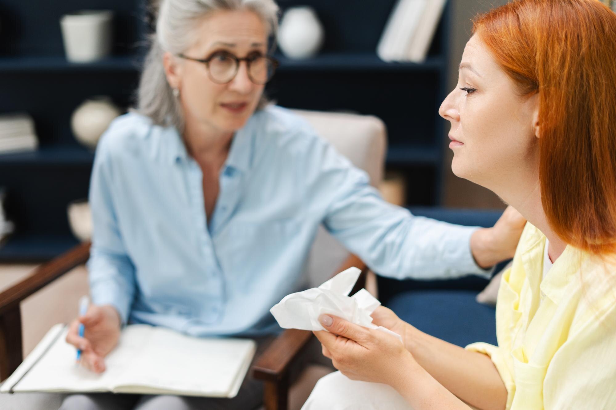 psychotherapist comforting crying patient during t 12fe78c2dd667be2cf4f