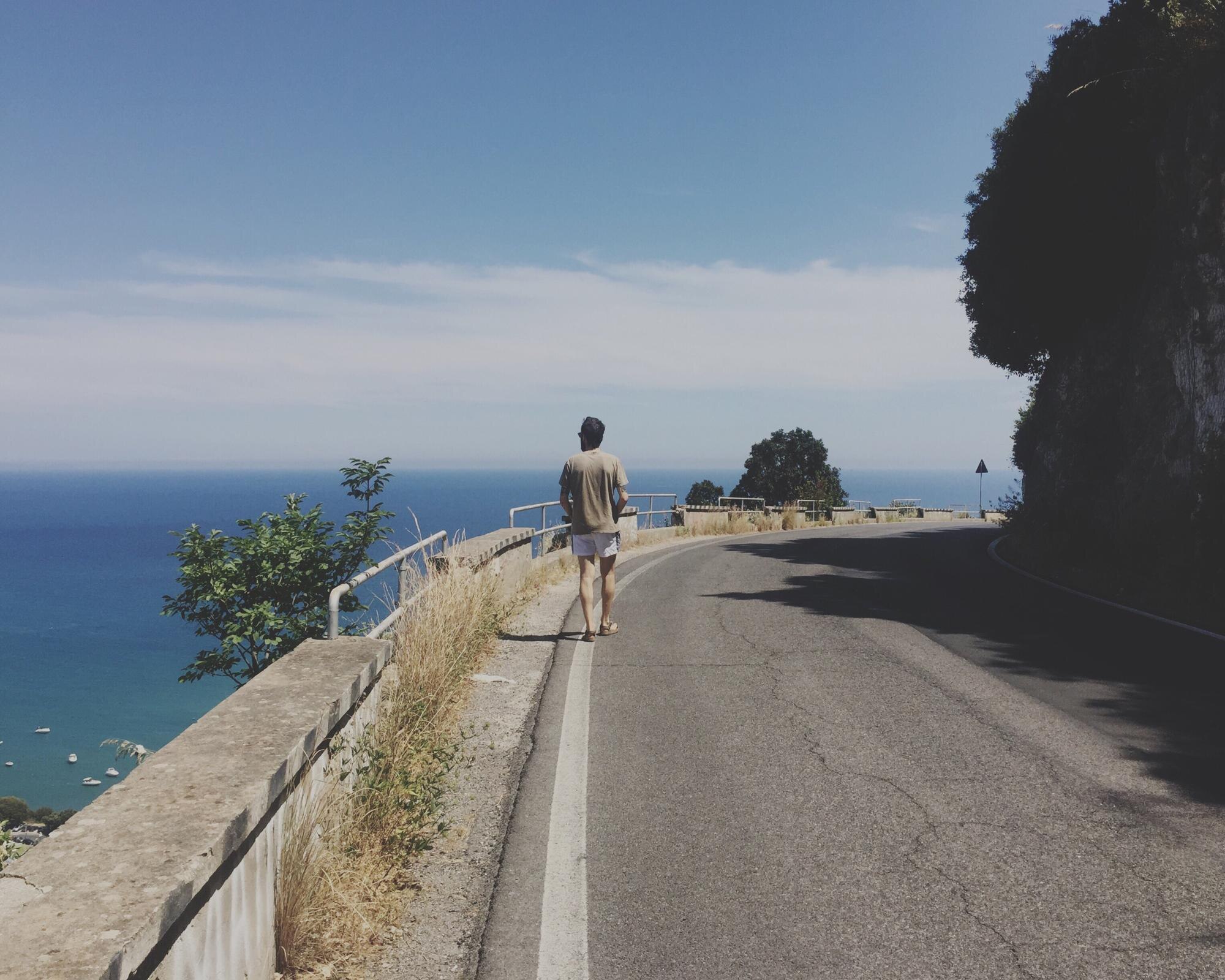 rear view of man on road by sea against sky 650d452b77ea77190f97 BTOURS