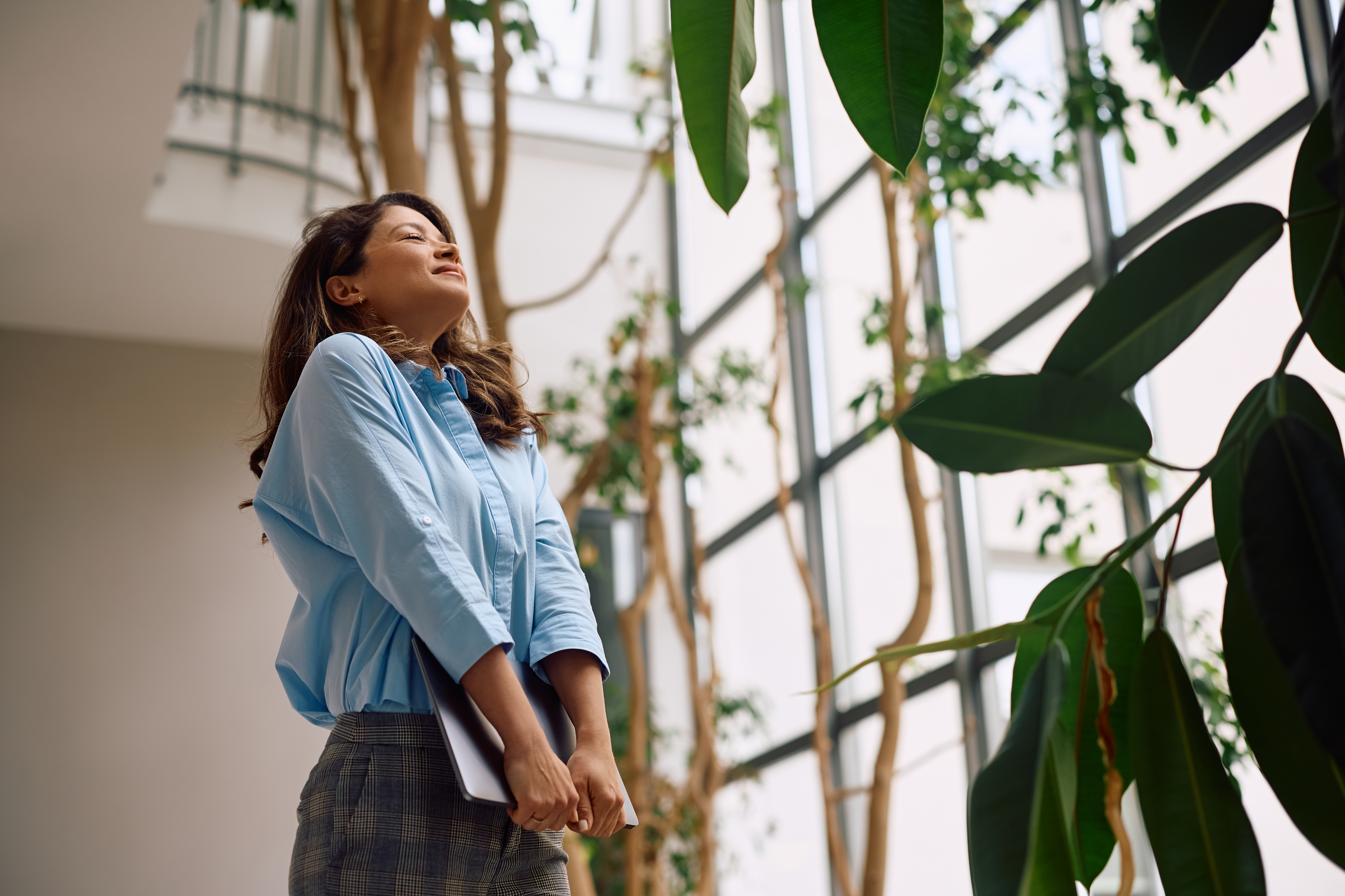 satisfied businesswoman with eyes closed in office e0679bd8d855b7991009