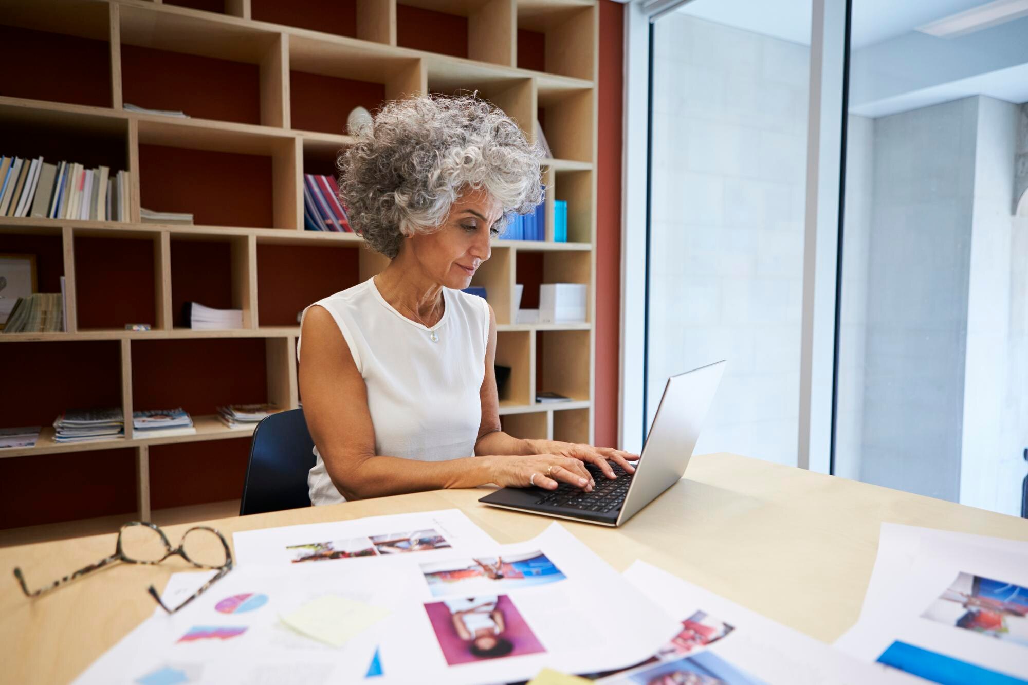 senior businesswoman working on laptop in office a7ebe85ca2bab7ef9a2d