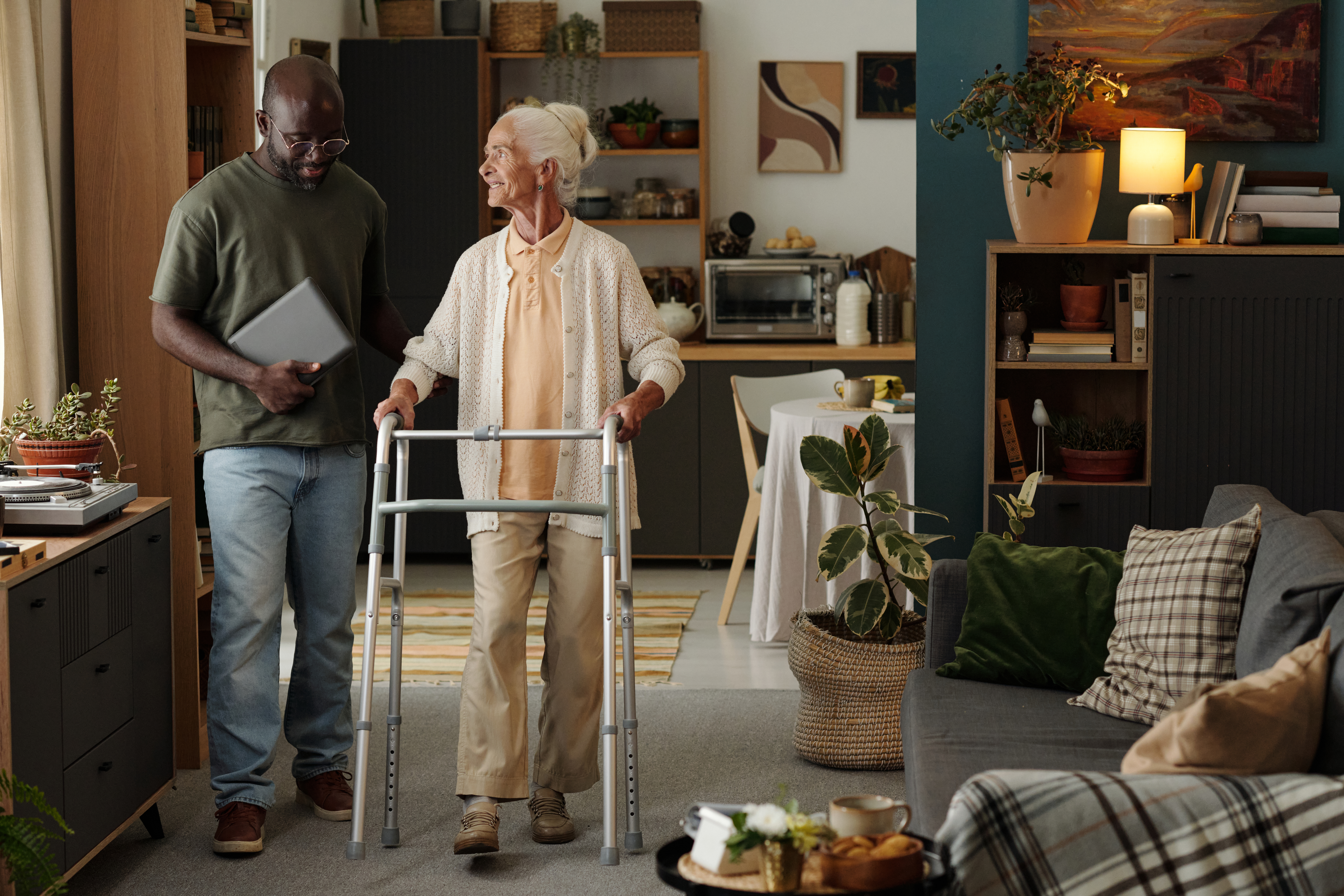 senior caucasian woman using walker while black ma a32e6dbe29cdf89b76c9