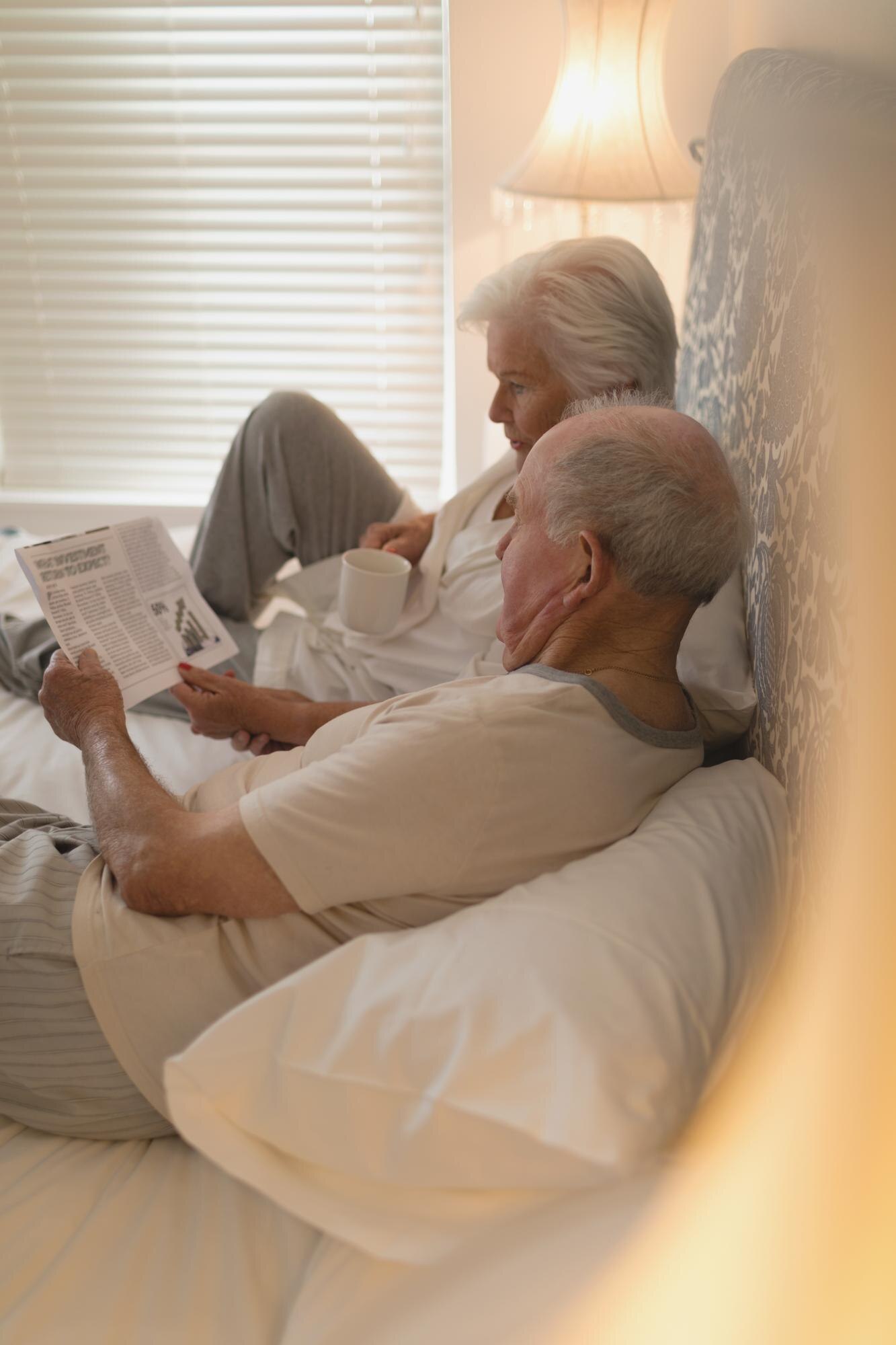 senior couple reading newspaper in bedroom a0596ad2ead85c5a3f9f