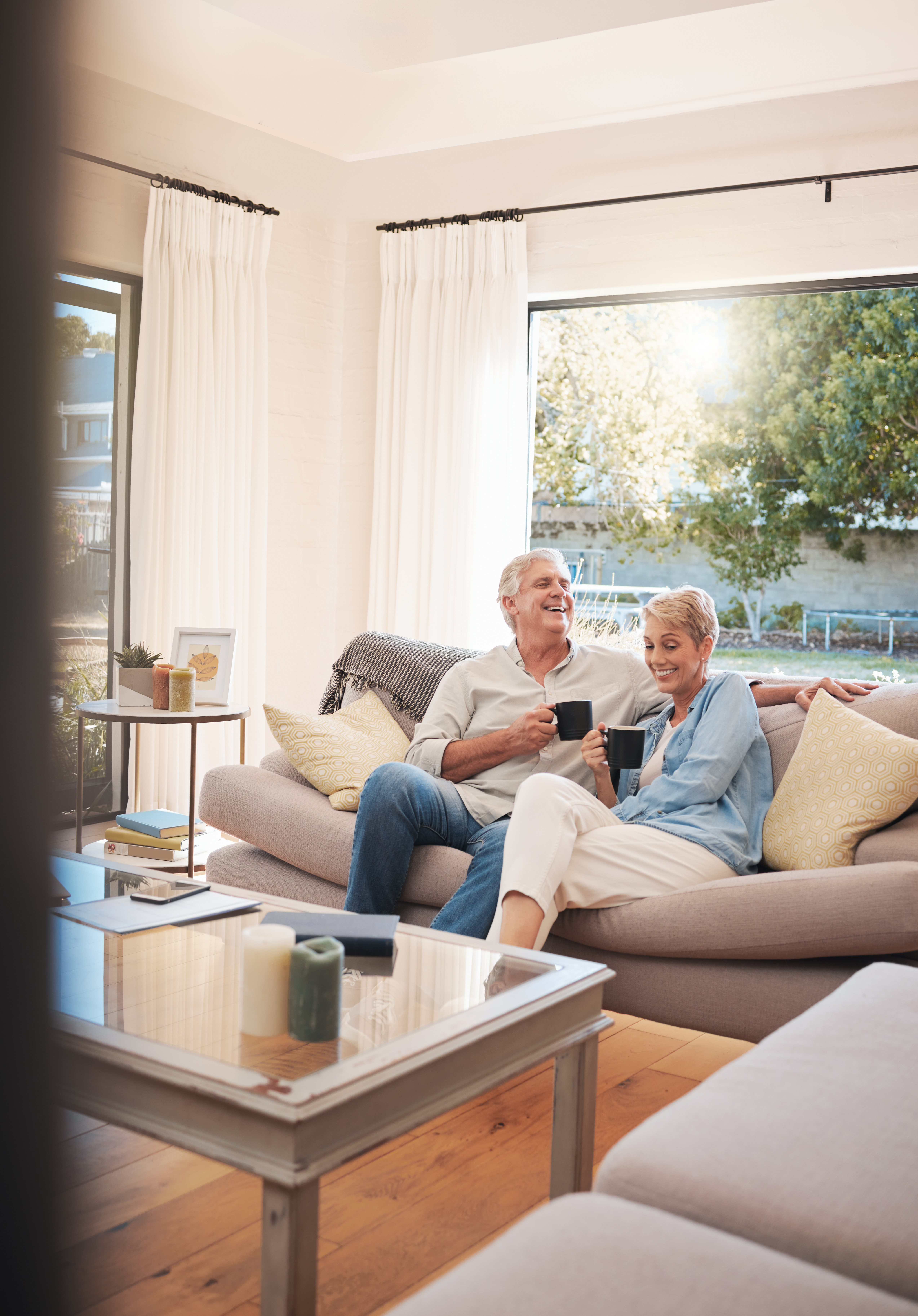 senior couple with coffee or tea and relax on sofa 9a900504de08f1a2d245