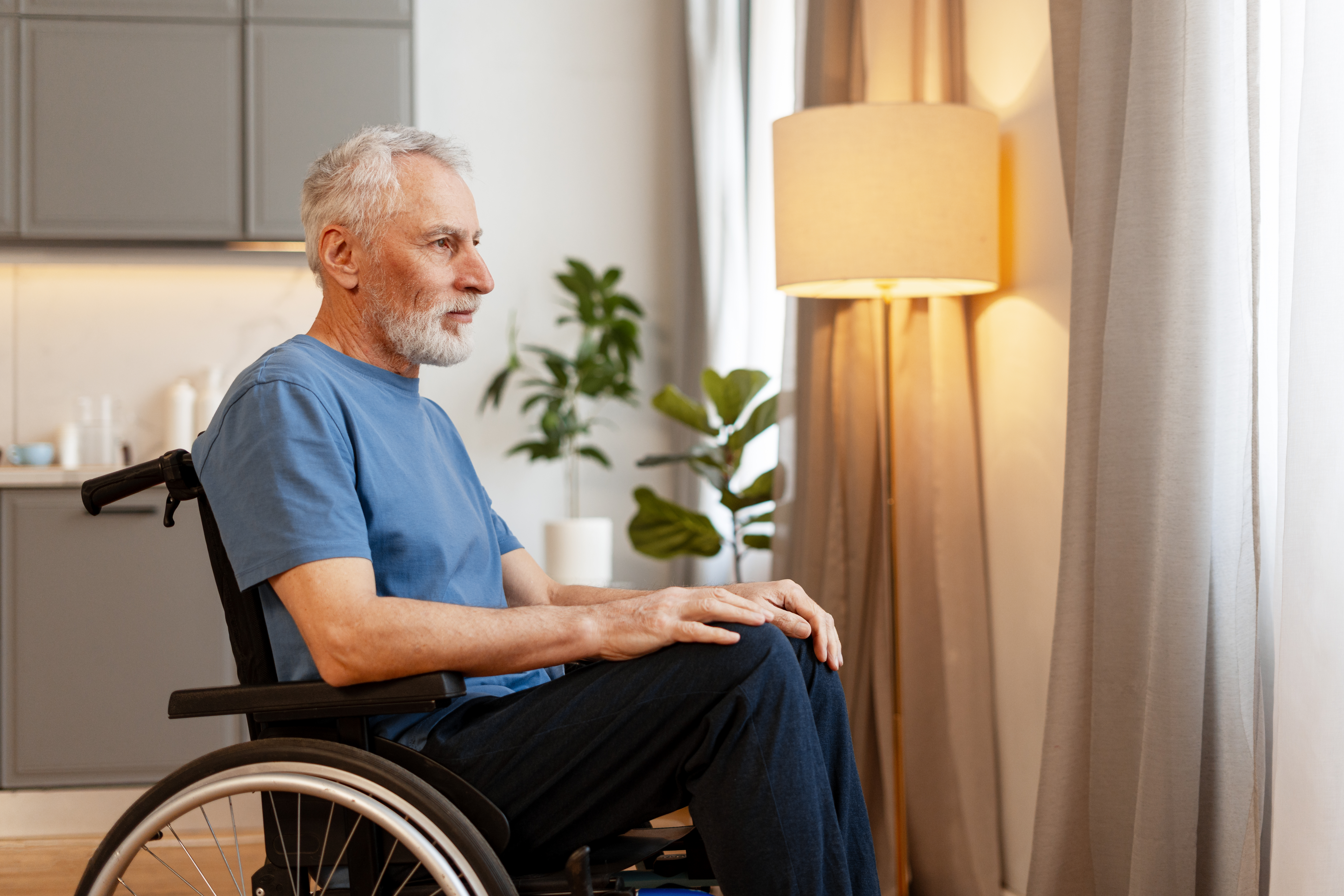 senior man sitting in wheelchair looking out windo 8146f1066c826e389455
