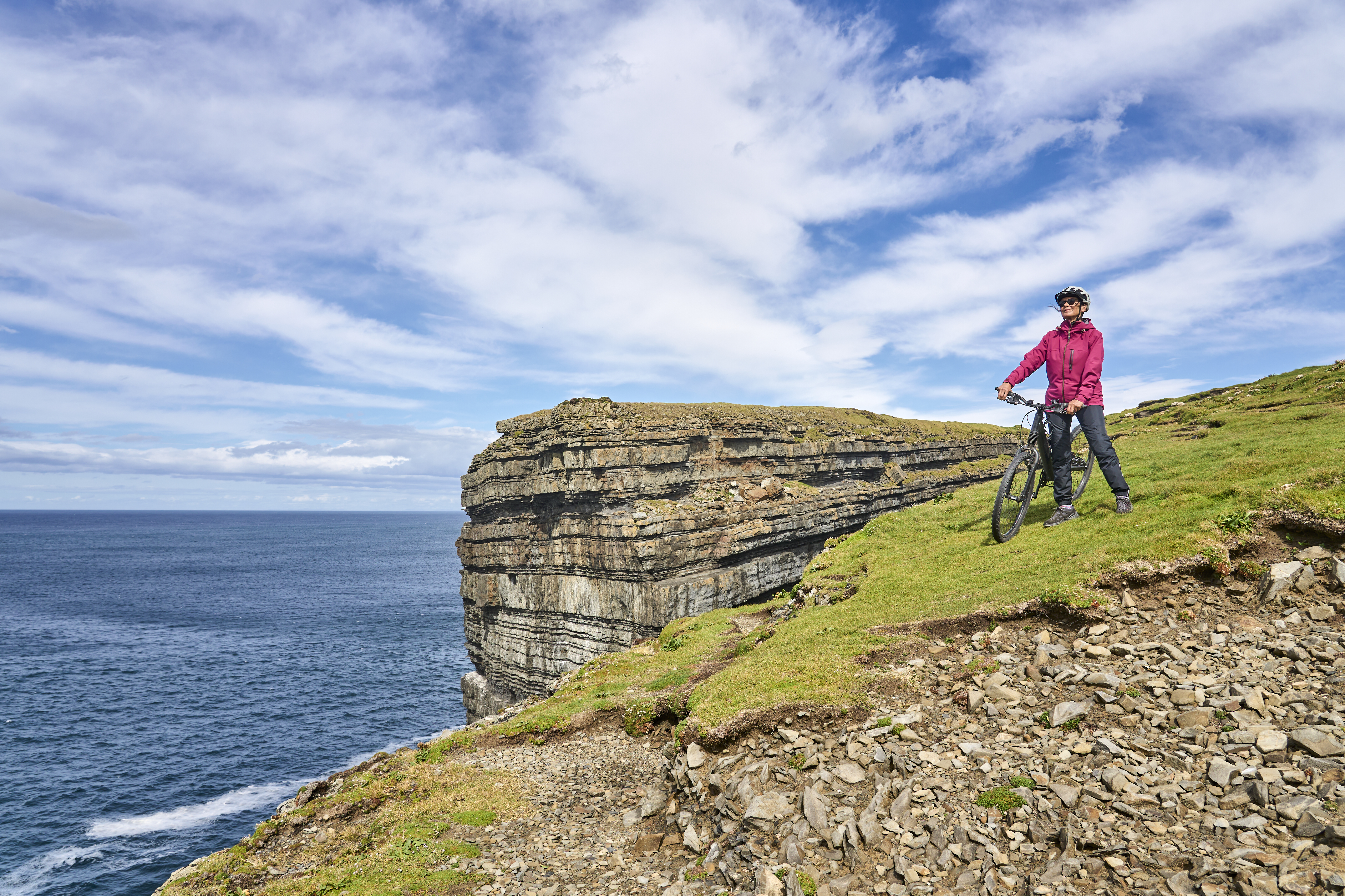 Hidden History, Open Roads: Lesser‑Known UK and Ireland Sites for Your Self‑Drive Itinerary 3 senior woman riding her mountain bike in ireland 5acc649ffcce69834878 BTOURS