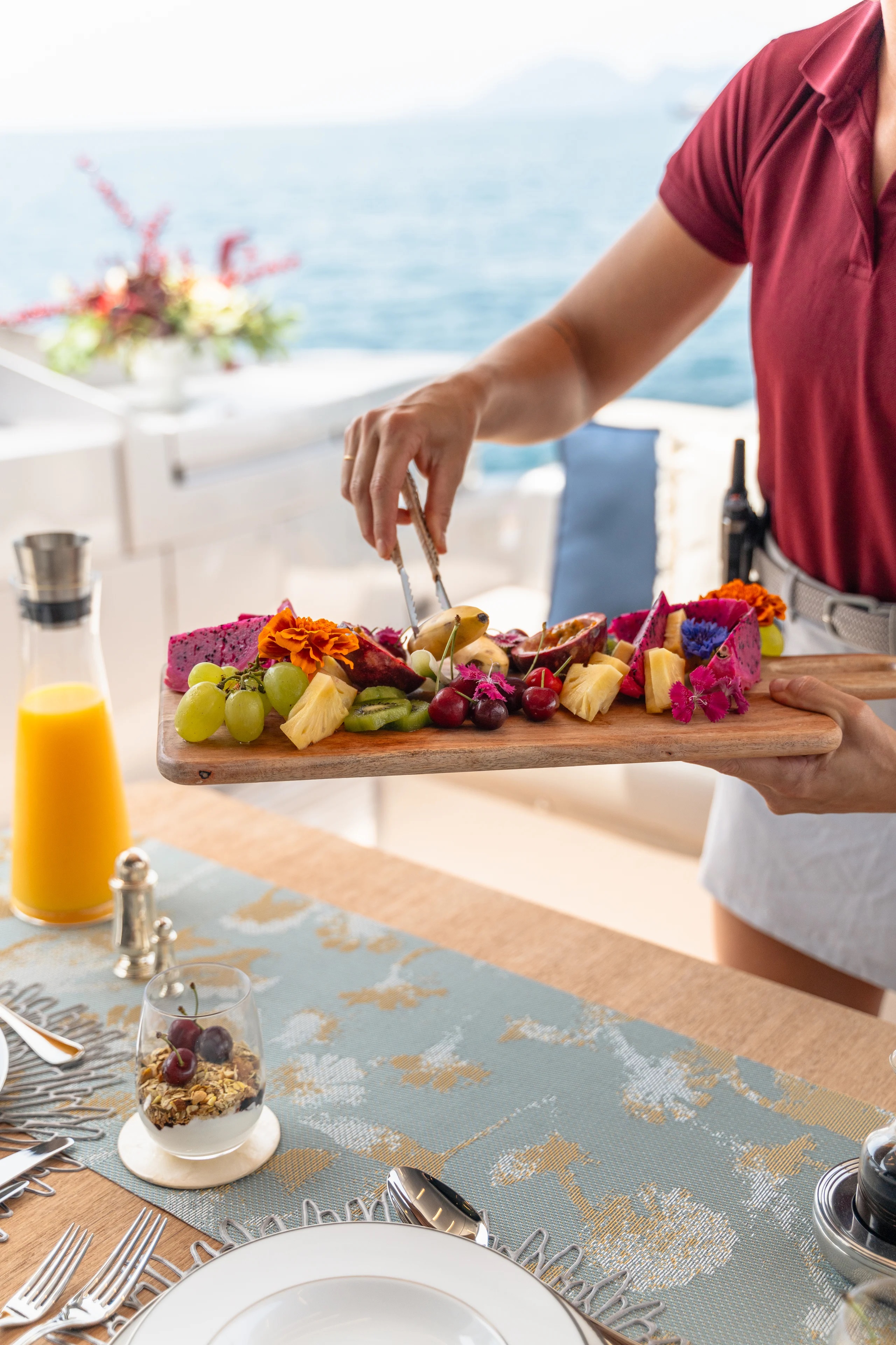 Professional yacht crew providing personalized service to guests on deck, showcasing attentive hospitality and luxury amenities.