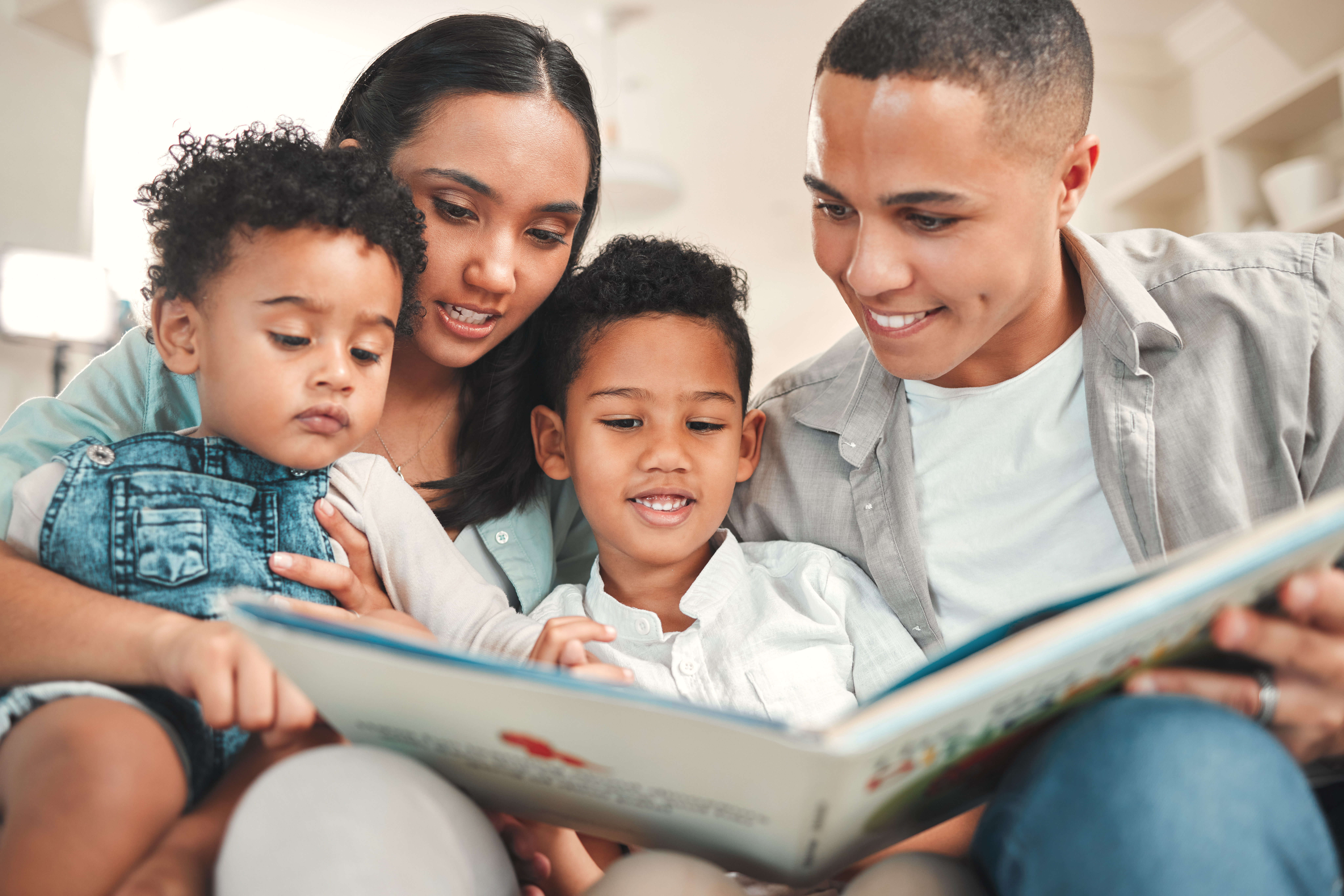 shot of a young family reading a book together on 5367b6ac4e9448aa59a2