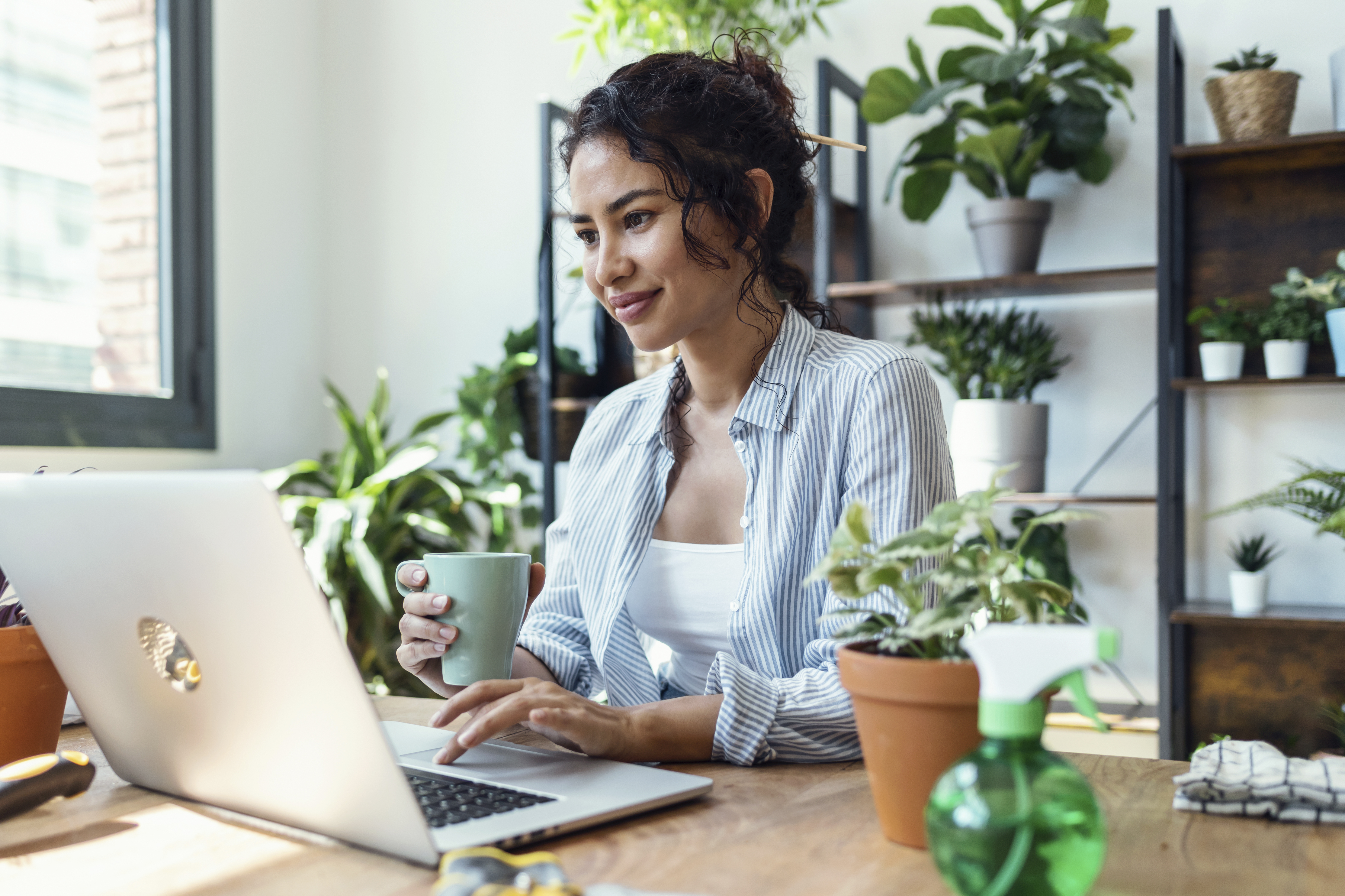 shot of smiling woman drinking a cup of coffee whi 40faf66795ac44e48c74