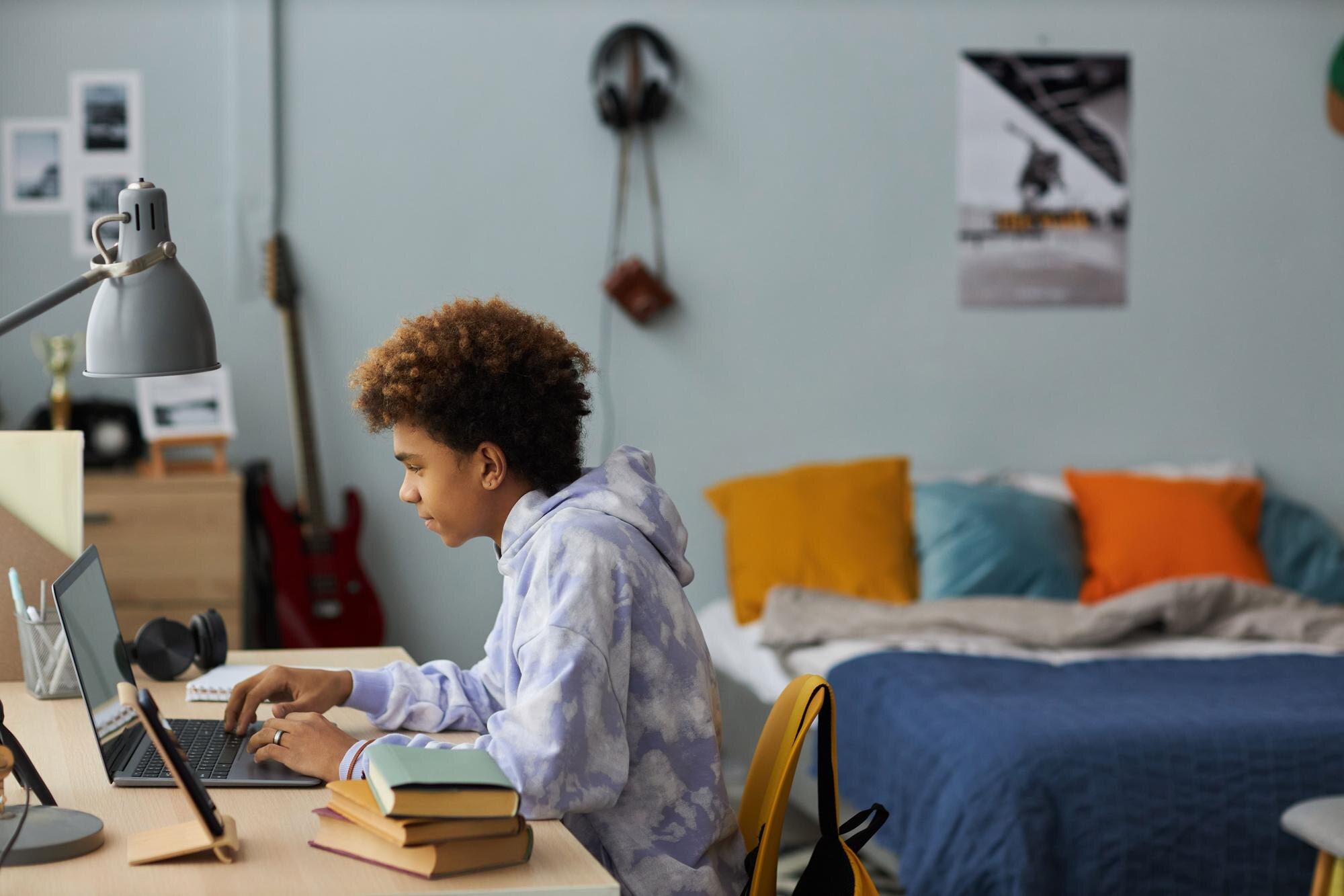 Side View Of Youthful Student Sitting By Desk In F 7769999bc5c6d12e6d6e