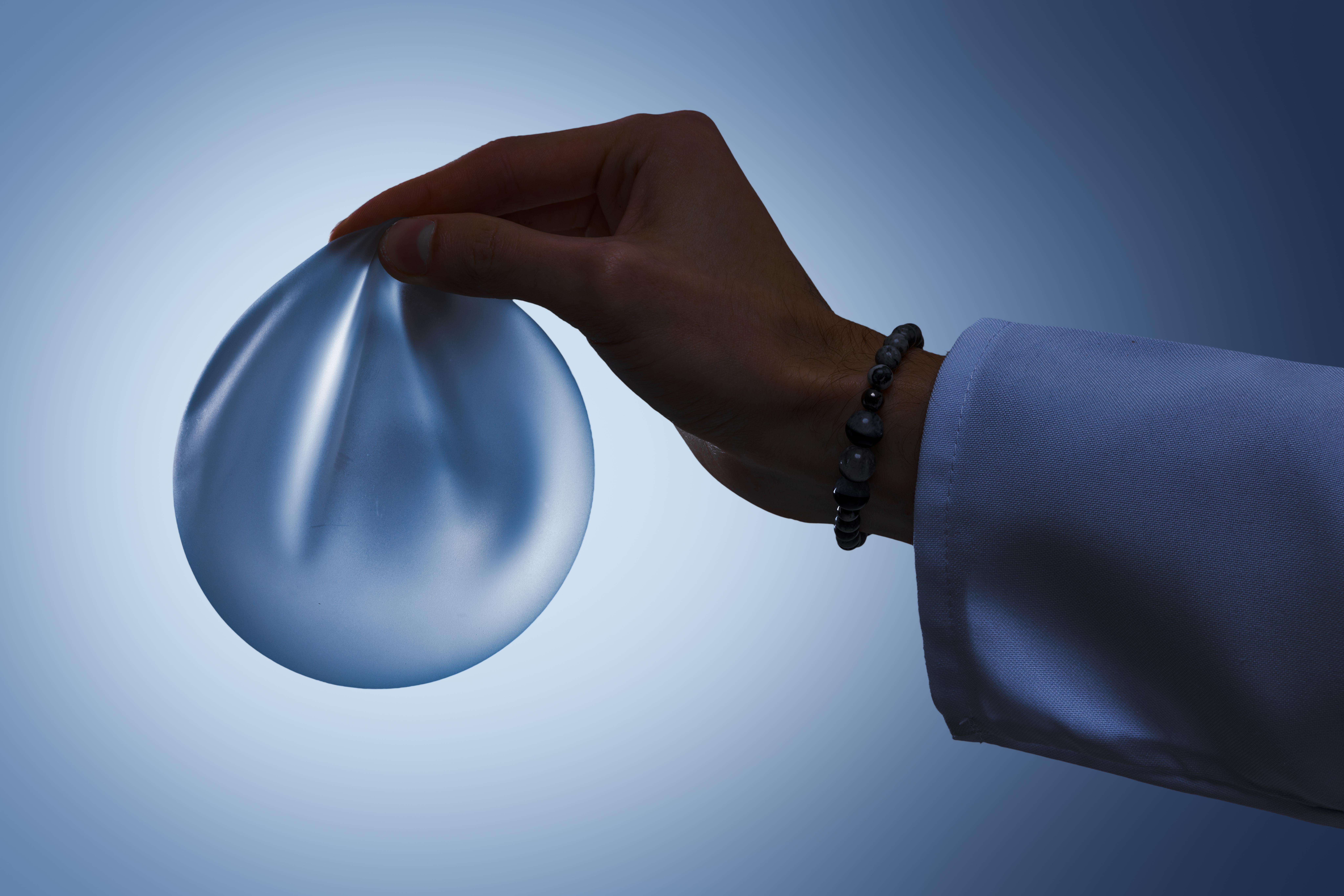 silicone breast implant in surgeon hand for mammop 79f66e33672796515894