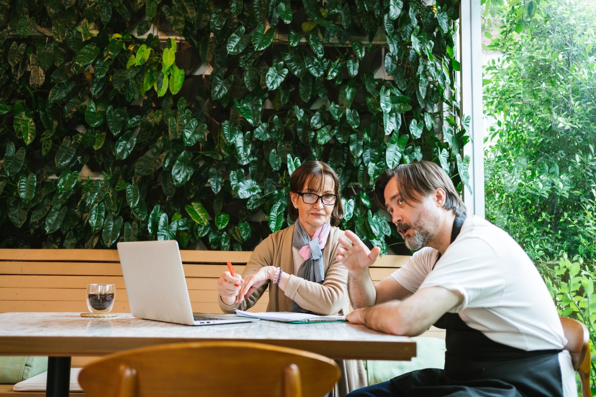 Green hosting for small businesses: save money, boost your brand, and cut carbon 1 small business cafe owner in apron meets with fina 2831ceeb90aab77f7185