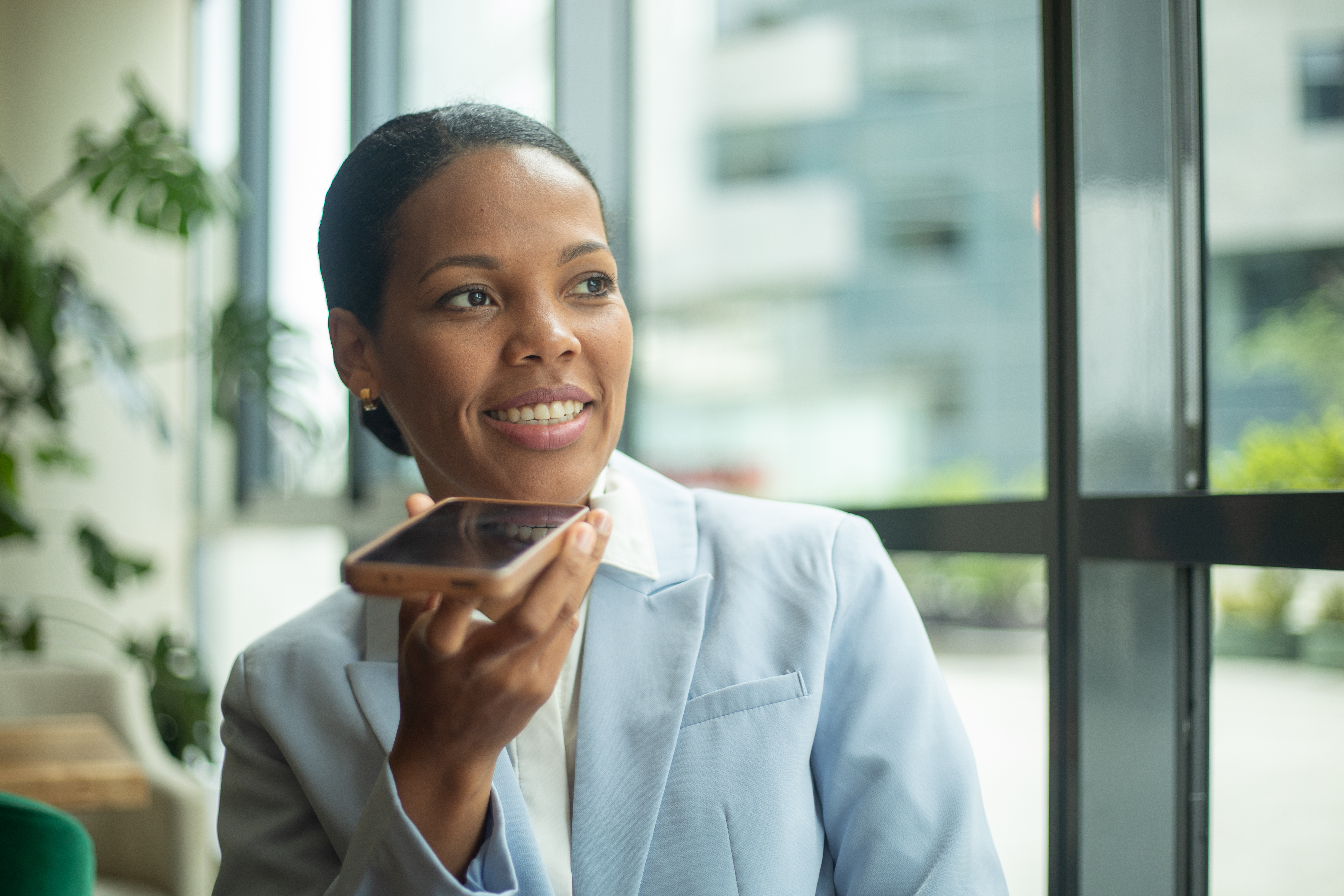 smiling businesswoman recording voice message on s 0a2300bba29f19ec7370