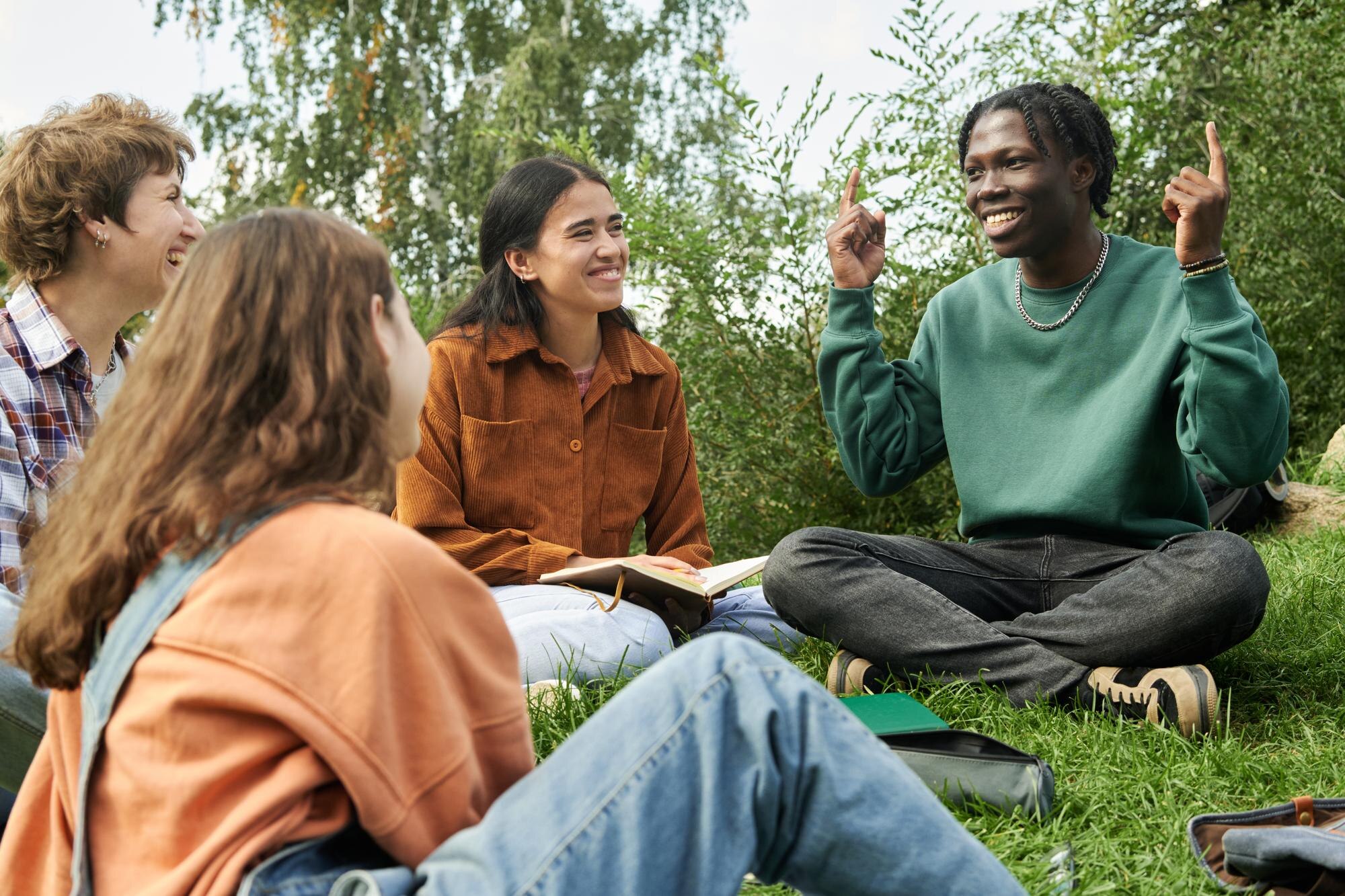 smiling diverse group of friends sitting outdoors 4c876e6409a8c7d5cd36