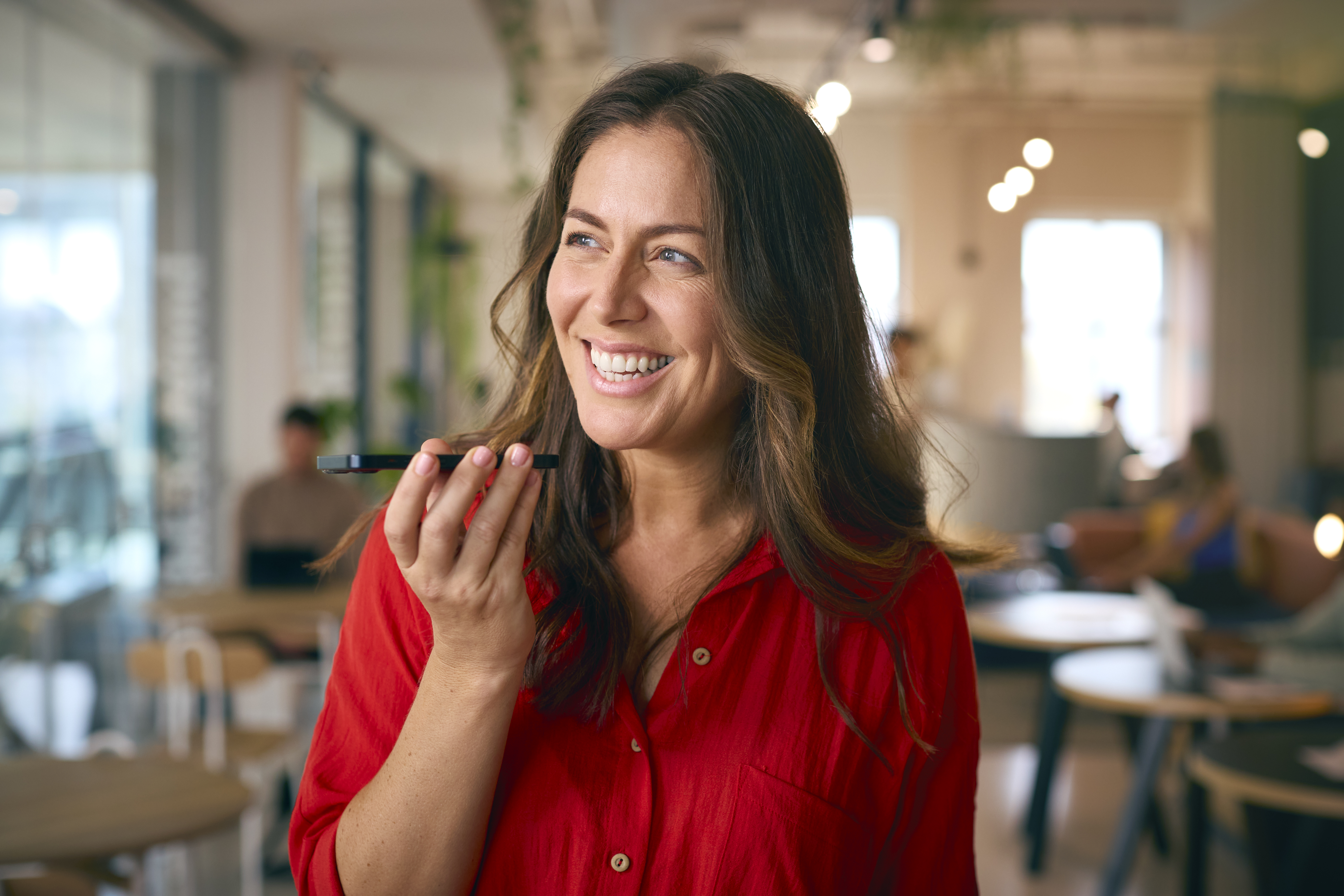 smiling mature businesswoman standing in busy offi 7a20d0f4f4773593d7d1
