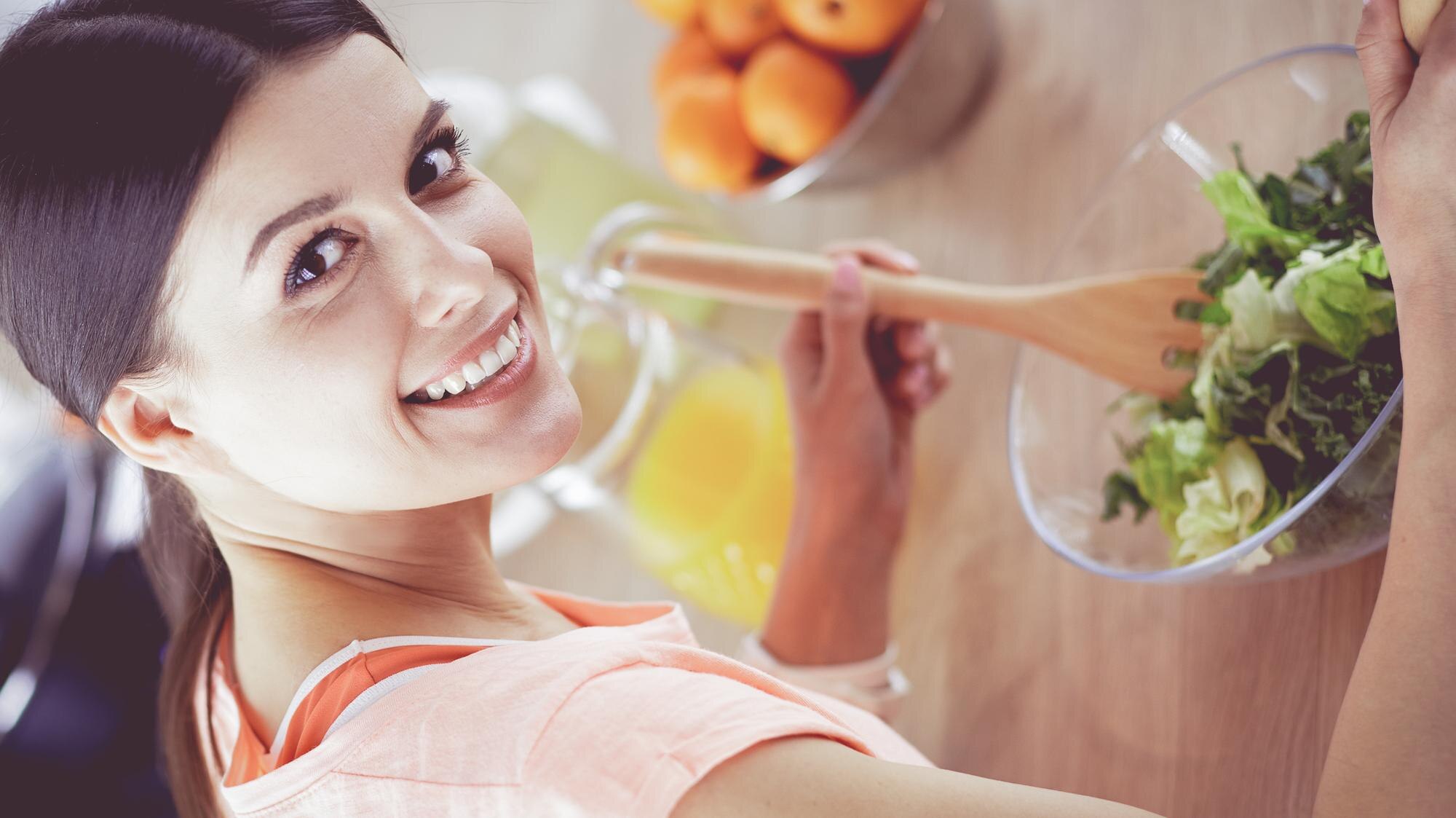 Smiling Young Woman Mixing Fresh Salad In The Kitc 66F167Ed4C6Dcd4Cceb4