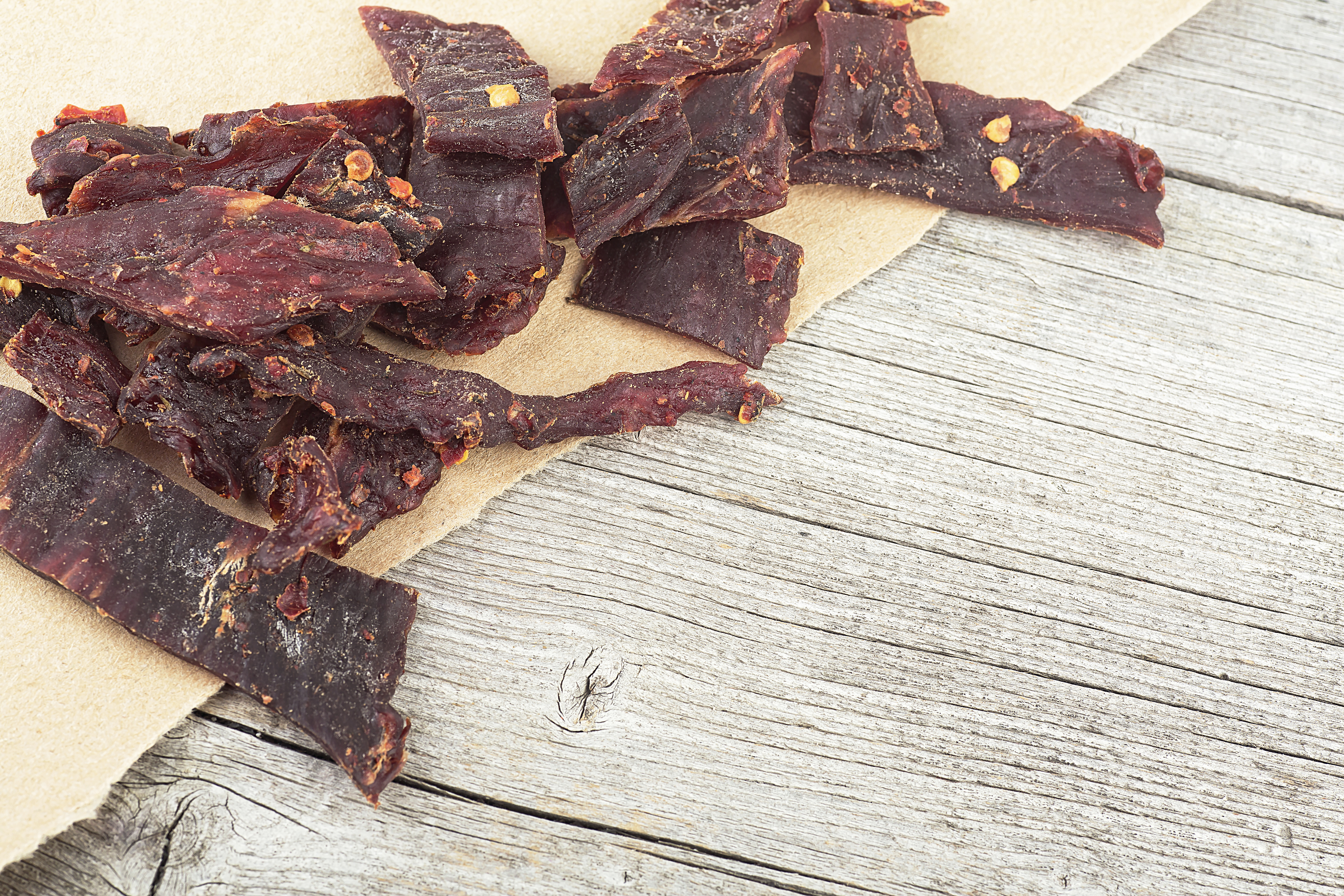 slices of gourmet beef jerky on a wood background
