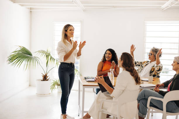 successful businesswomen clapping hands during a m 6a777078c5cc5abe3042
