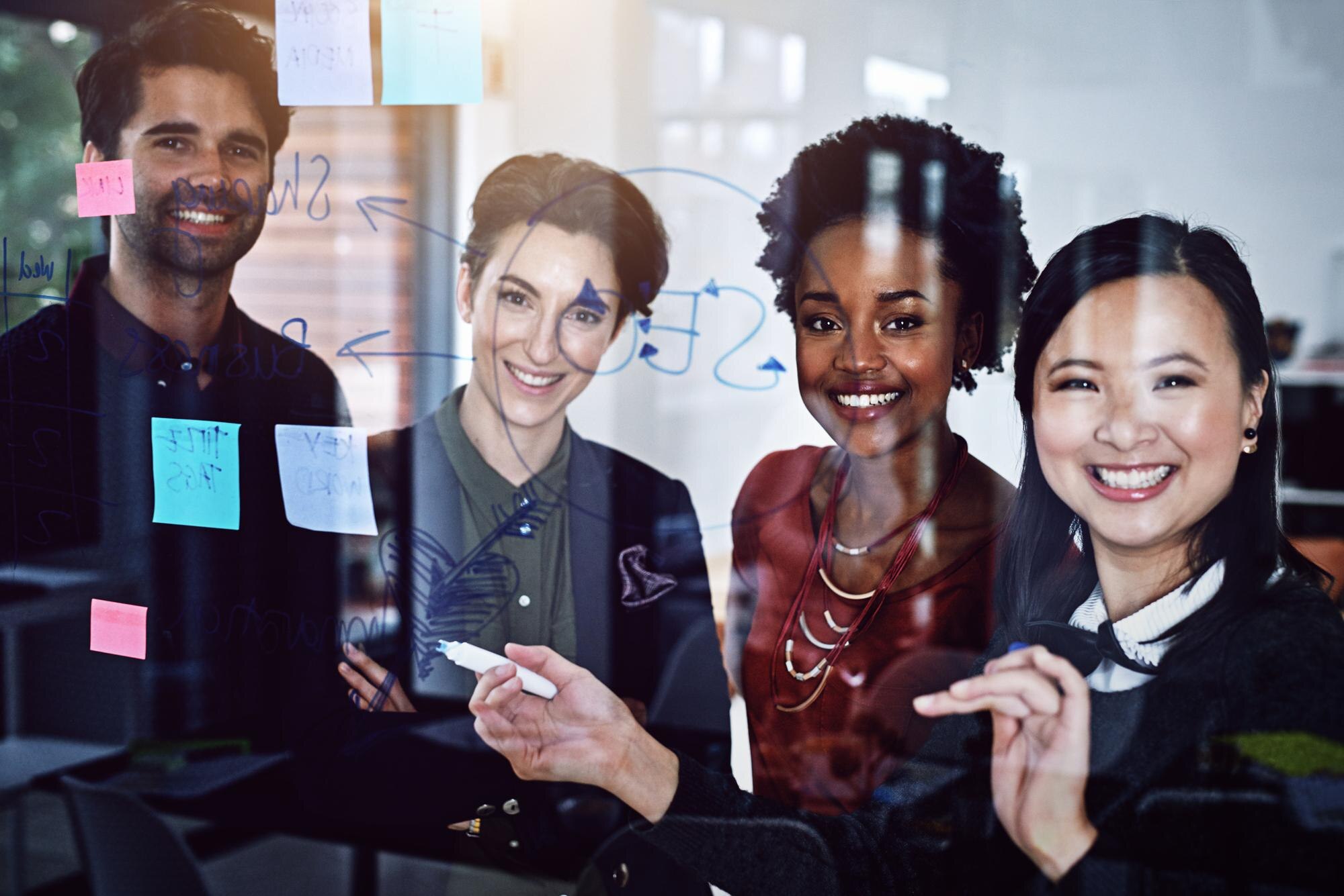 team of coworkers collaborating with post it notes in a conference room