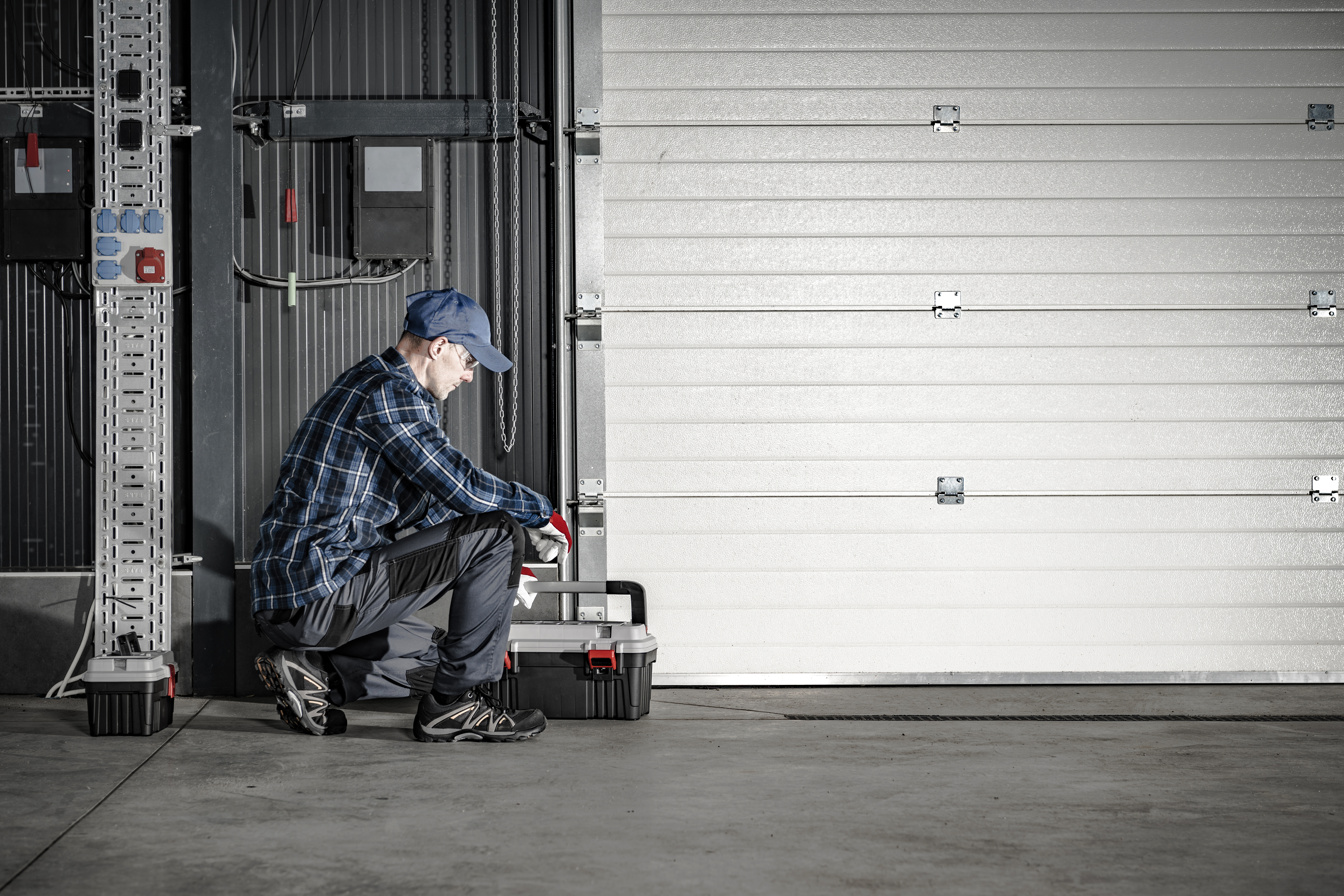 Unlock Savings and Longevity: The Power of Routine Garage Door Maintenance 1 technician servicing commercial dock garage gate 503167b08ad173453501