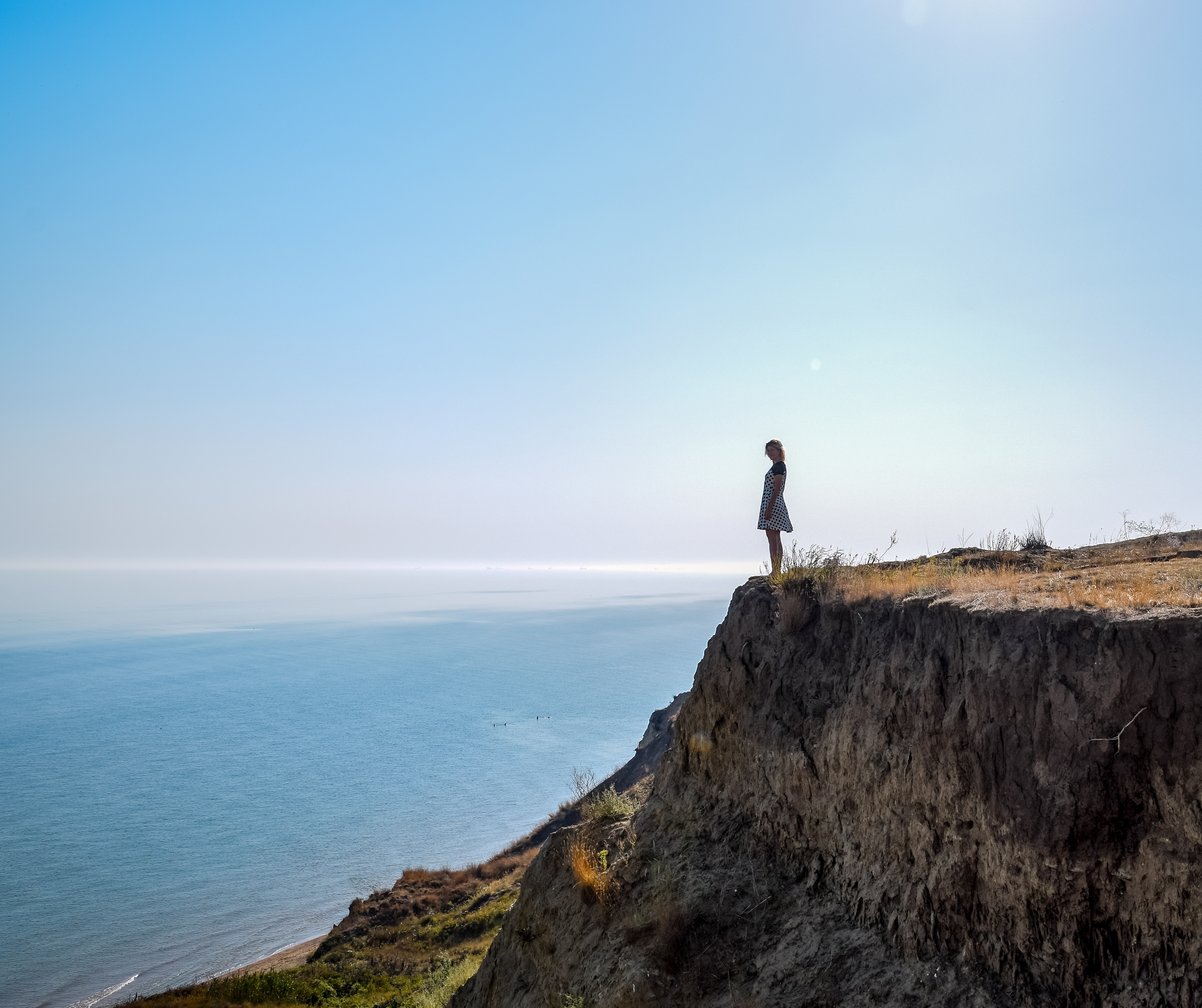 the girl is standing on a cliff near the sea a3538c37c790ab6e7350 BTOURS