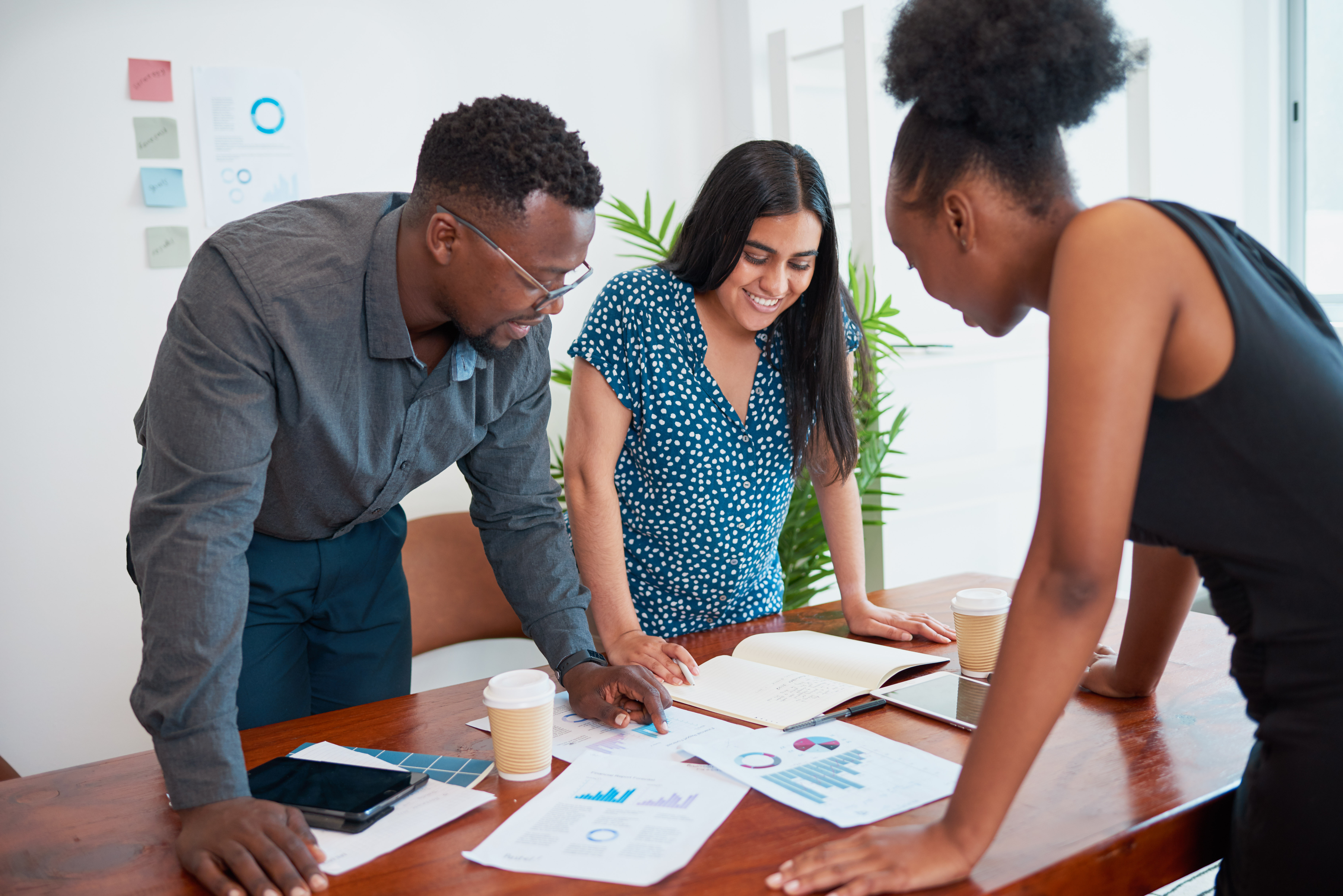 team members standing at a table collaborating