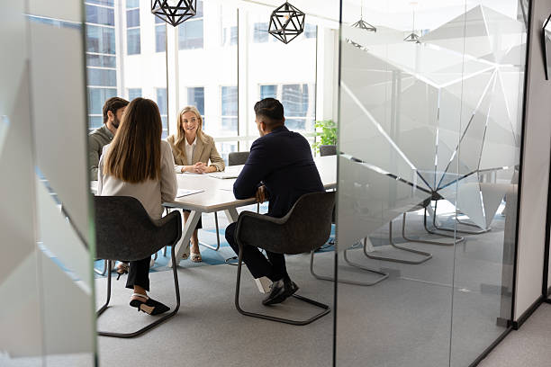 Business team discussing contract details in a modern office meeting room, emphasizing collaboration and legal strategy.