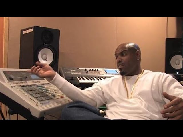 Experienced trap producer explaining music production techniques while surrounded by professional audio equipment and studio monitors.