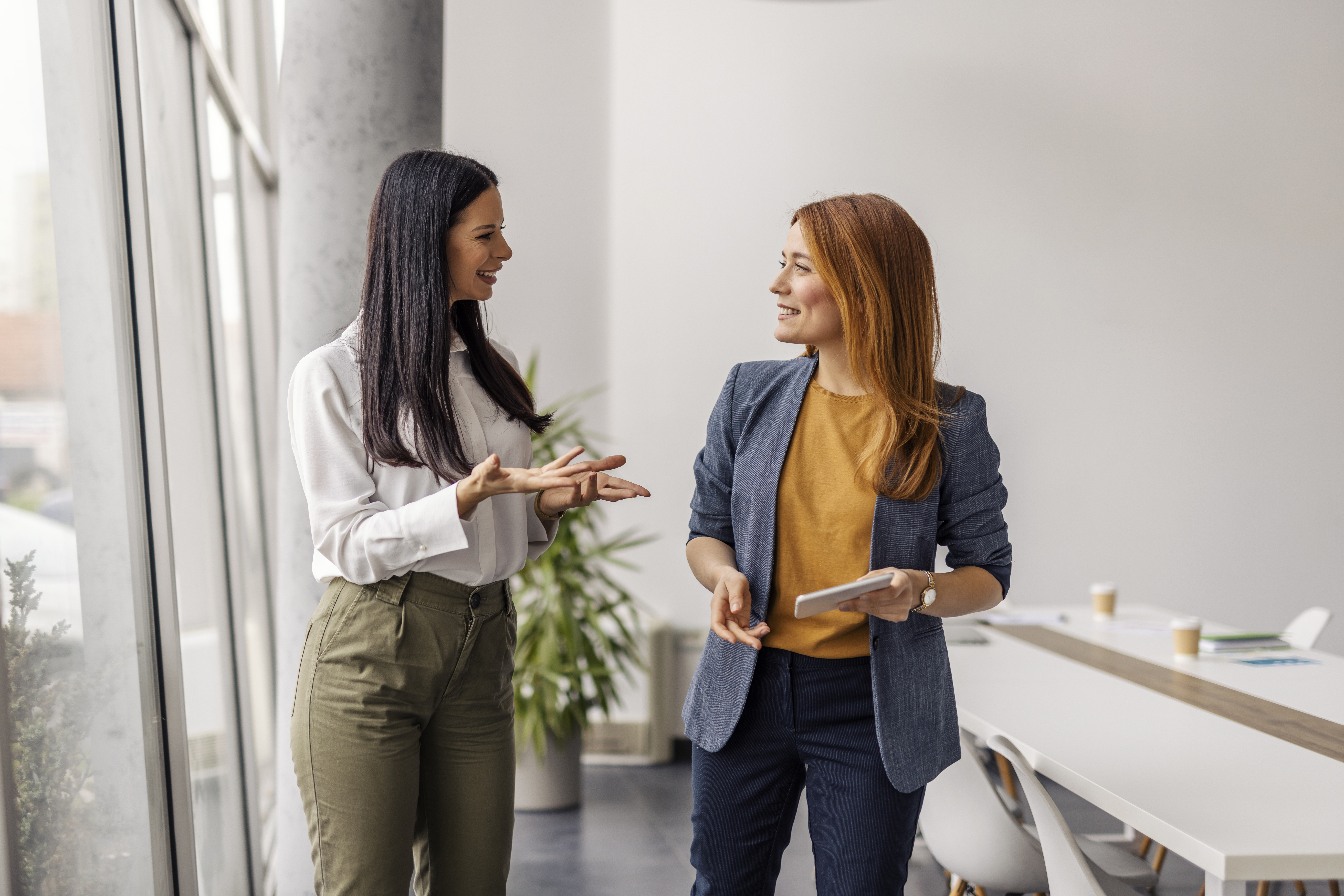 two female coworkers standing at corporate office 17d2dd5755917e119c82