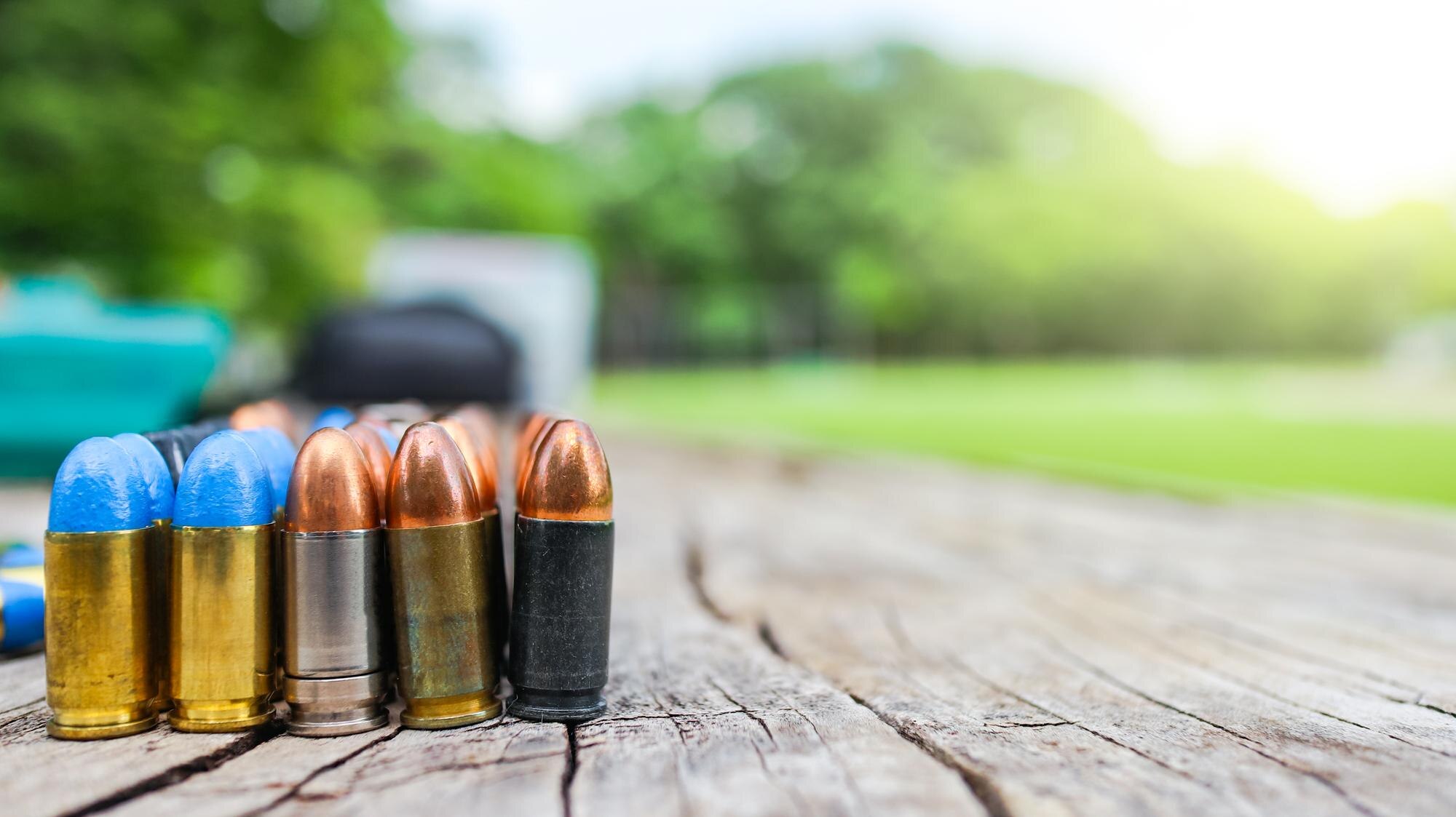 various types of bullets displayed on a wooden sur 6be4fbe4ab8ebcdd5196