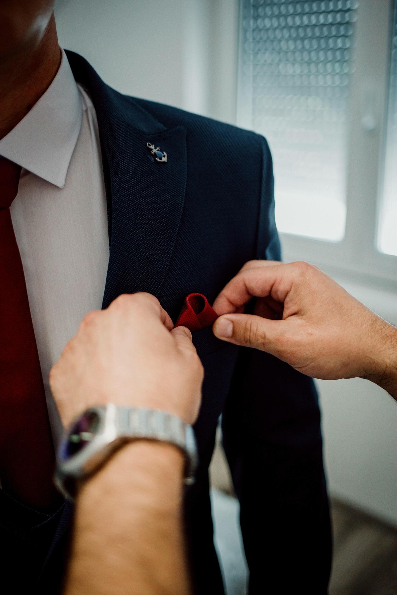 Crafting the Perfect Wedding Suit: Tailored Just for You in Bangkok Vertical Shot Of The Man Putting A Red Ribbon On T Df670c891deceb75588f
