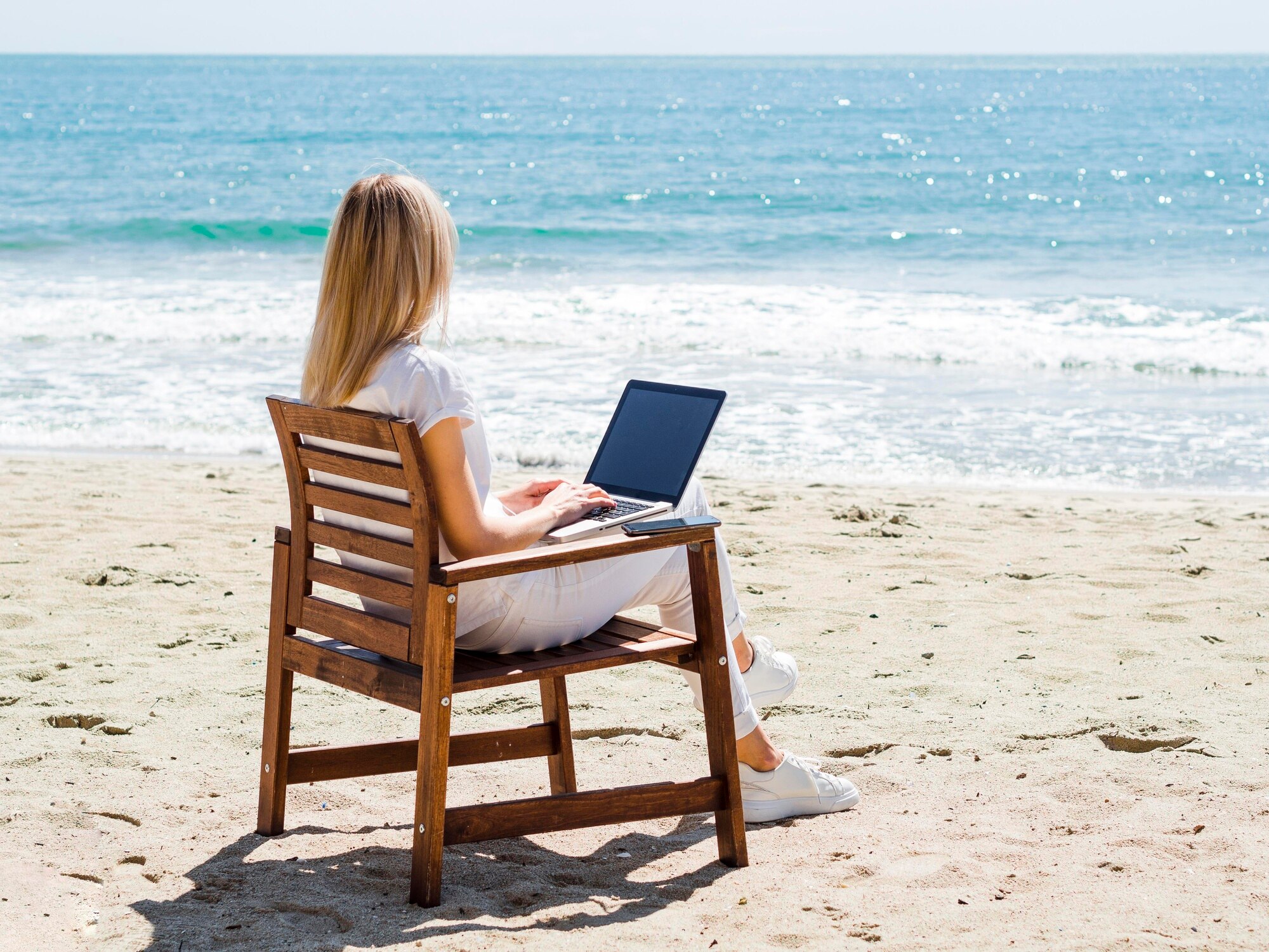 From Corporate Cubicles to Beachfront Offices: Your Guide to Travel Entrepreneurship 3 woman enjoying the beach while working on laptop b7dd5aa5fe3e132daa1f