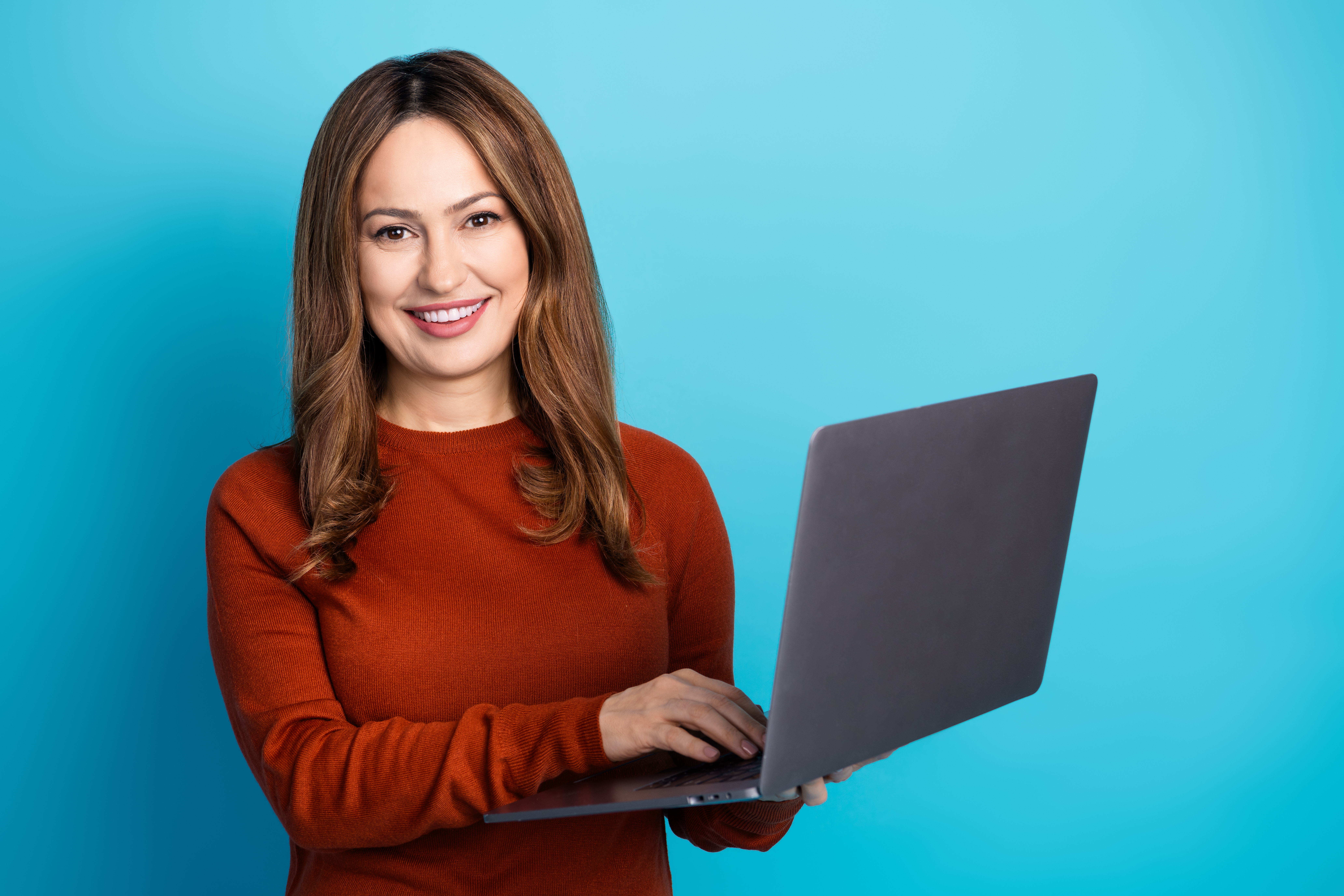 woman in casual sweater using laptop against blue 867dad2d211675fb9980