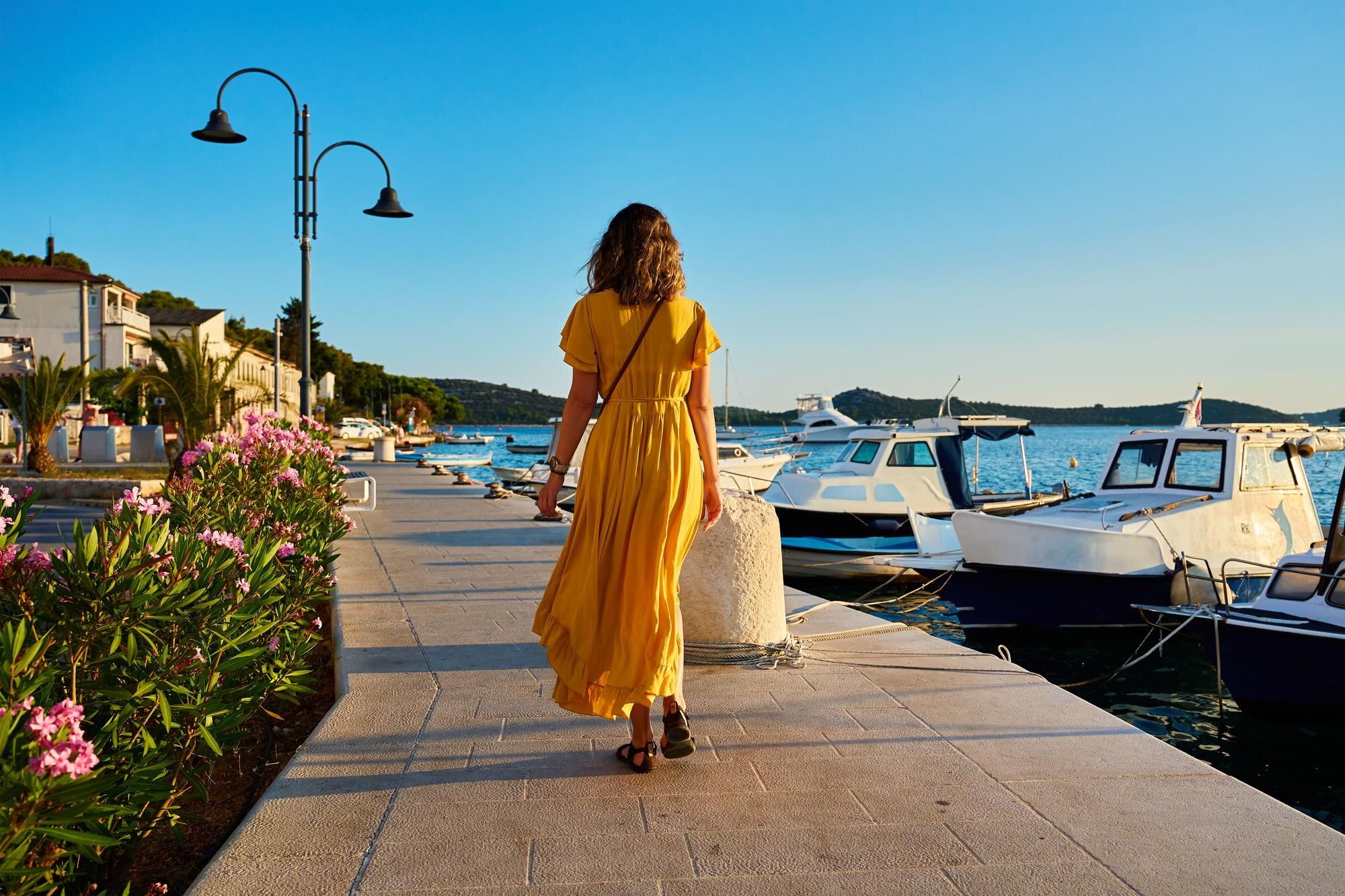 woman in yellow dress walking down sunny promenade 306f00a626b13782bdb8 BTOURS