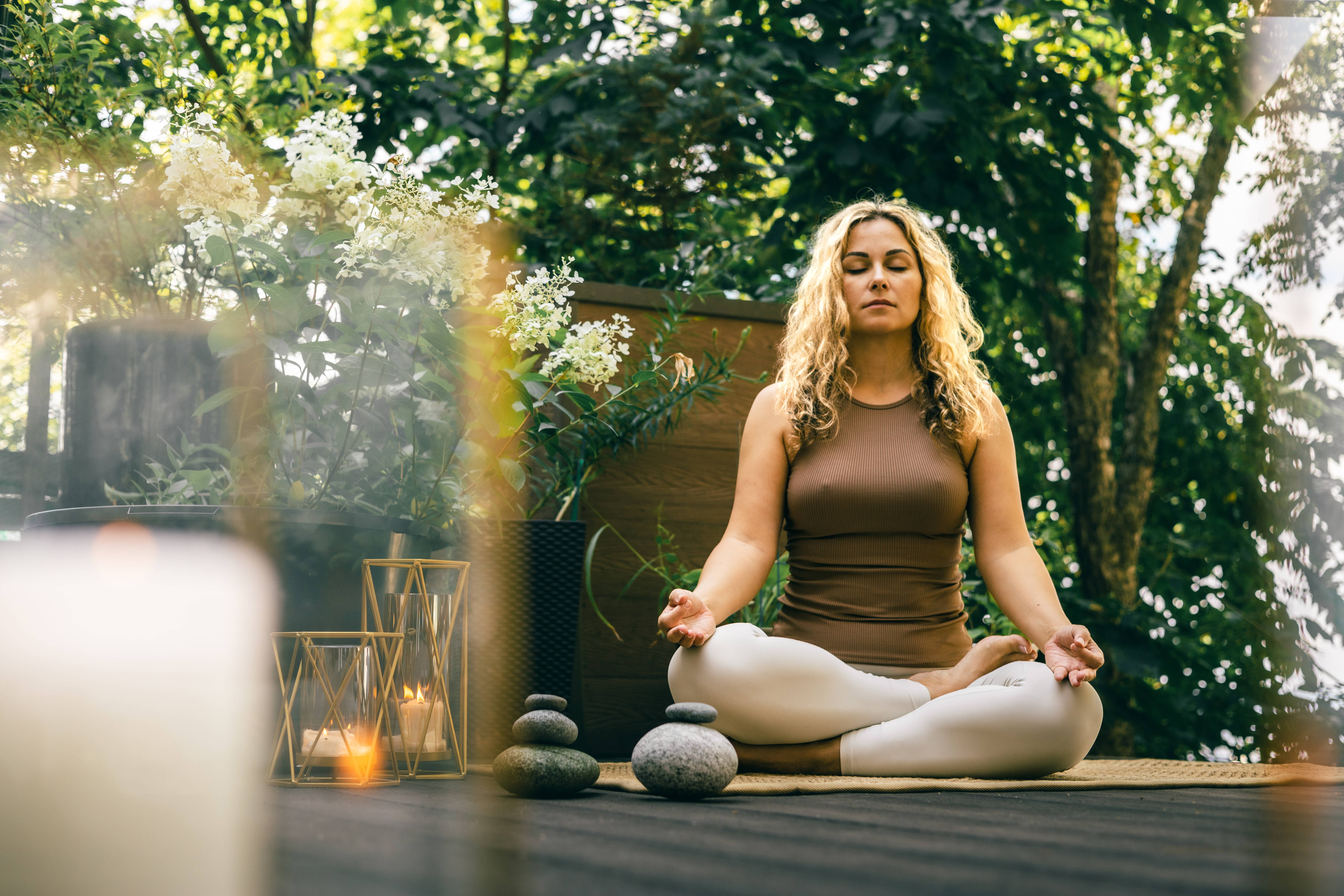 woman meditating in lotus pose outdoors with candl 2985a1ed5793cd3d66f8