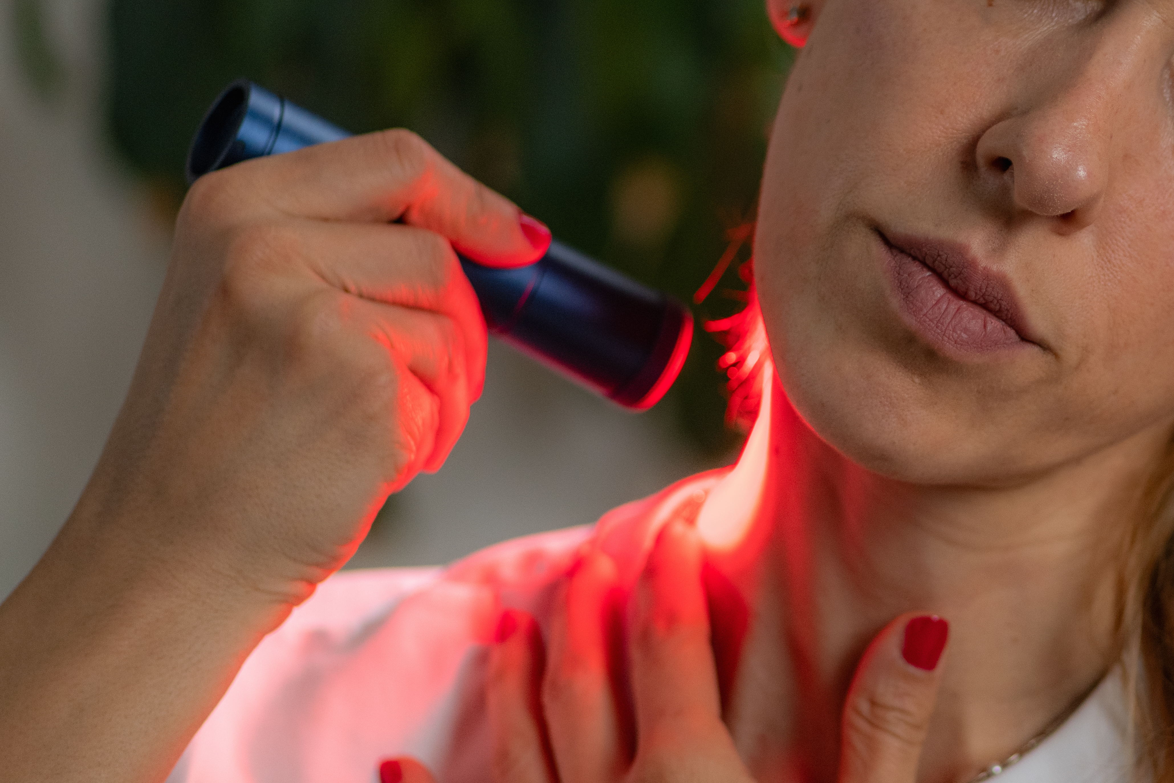 woman receiving red light therapy on the neck a t 7a9204d828761d213284