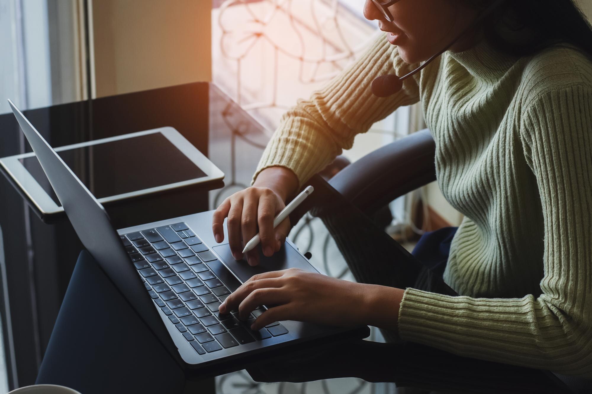 woman with headphone work on laptop computer at wo 18c050c22d870a22b319