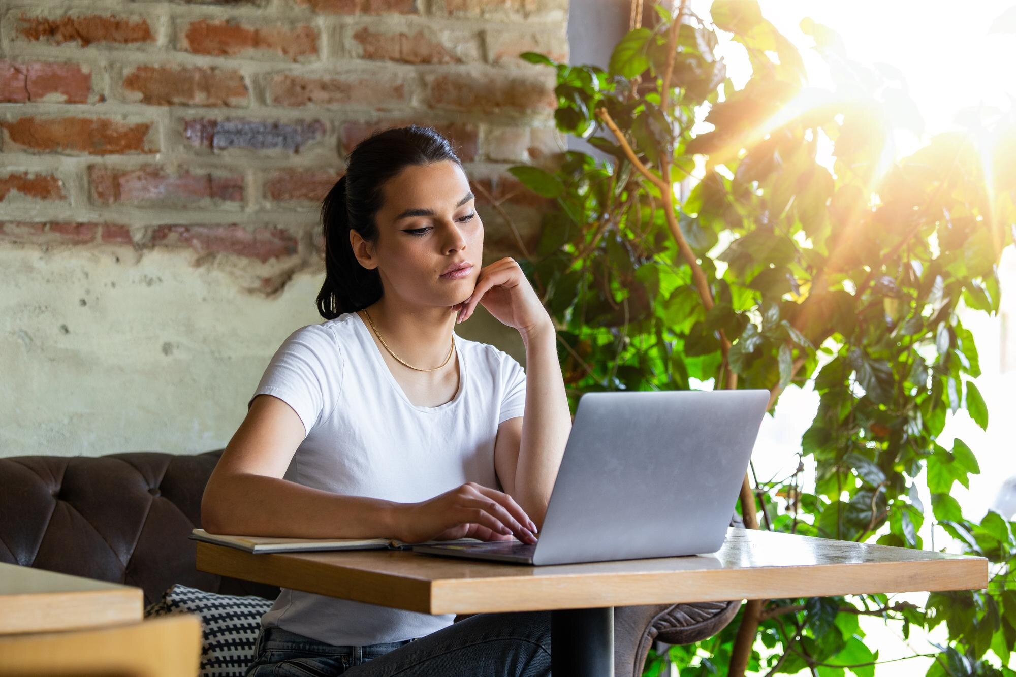 woman working on laptop at a cafe young woman work f7e631e89379eb2a4ac3