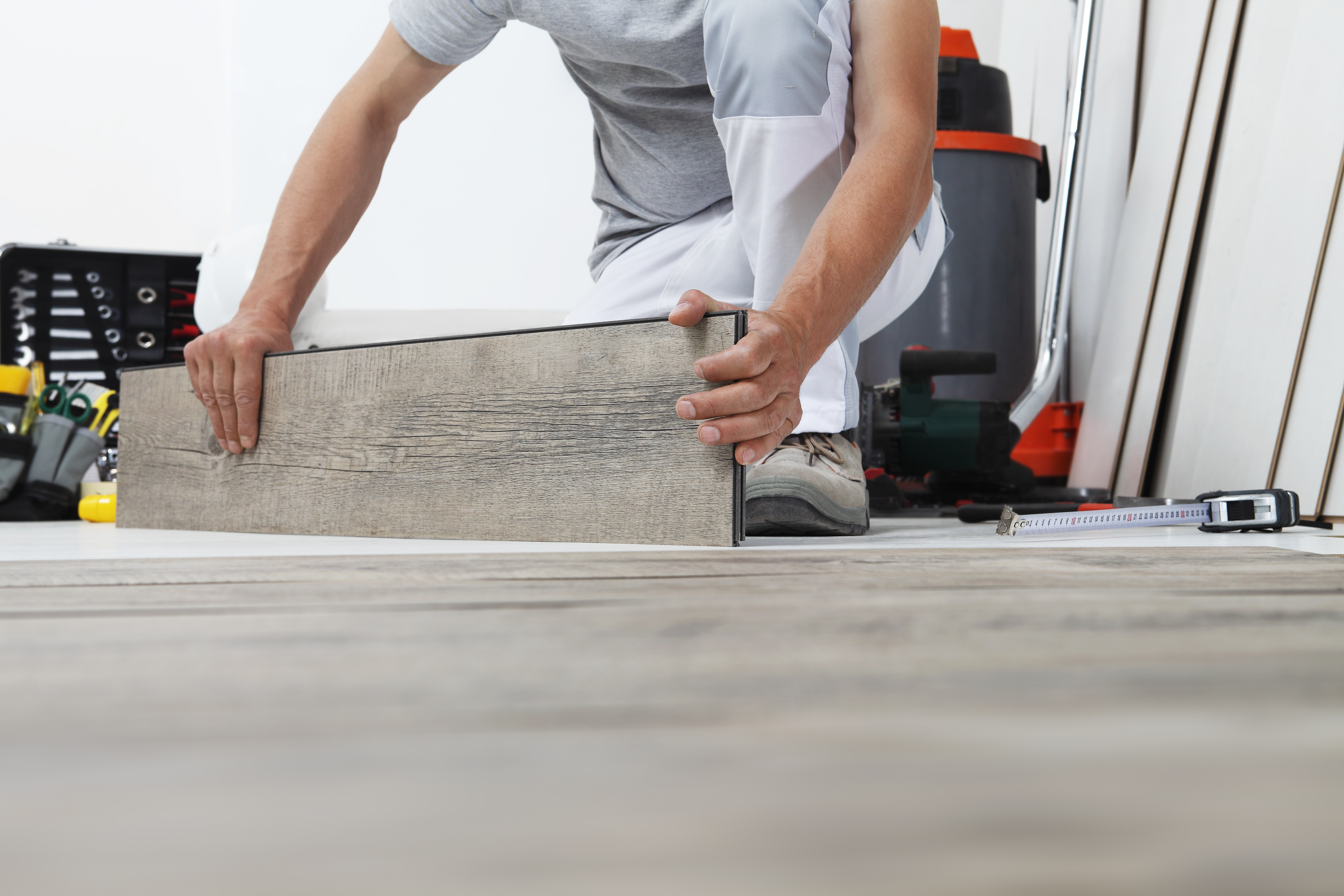 Worker hands installing timber laminate vinyl floo 511c22f04a0bbf860d7a