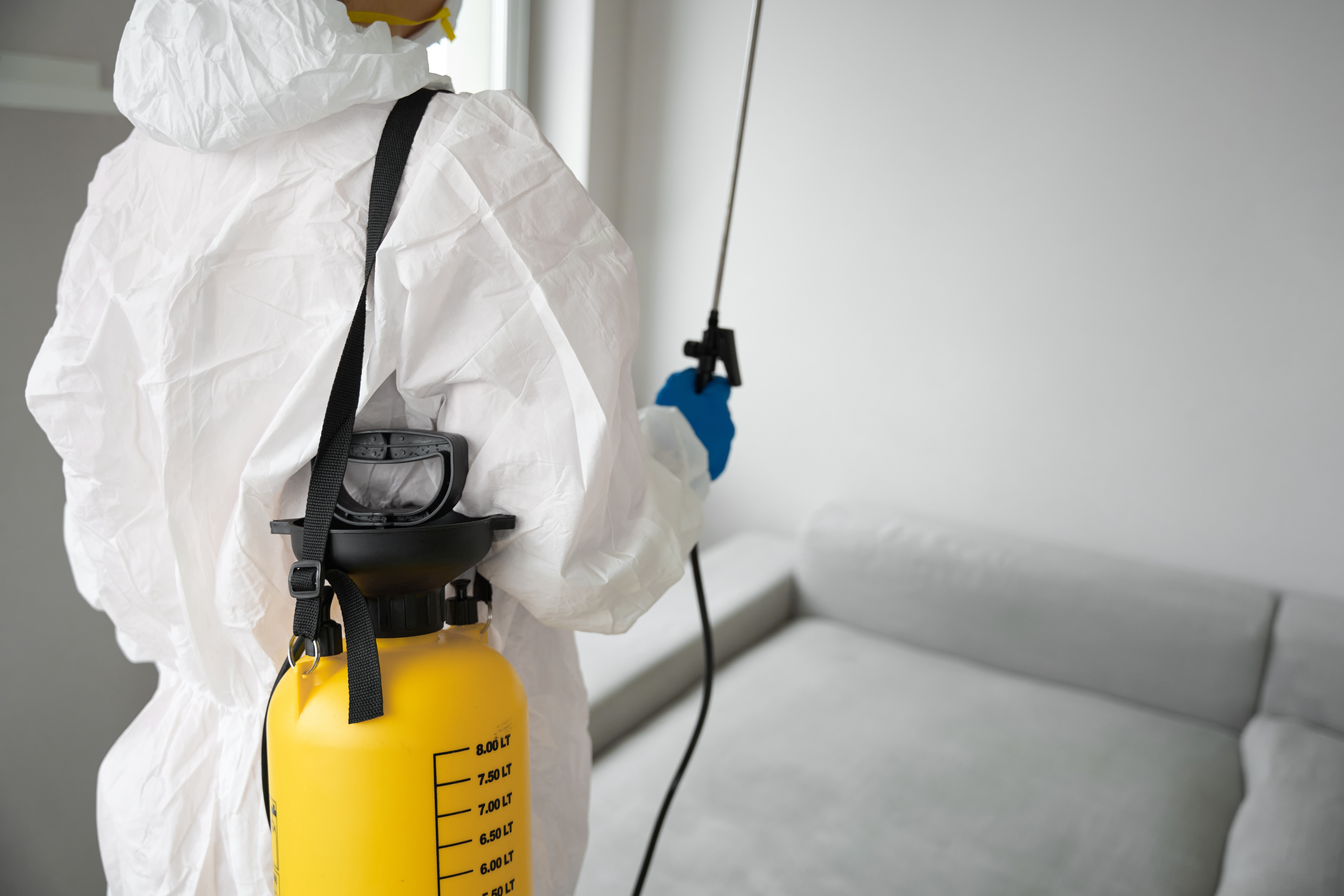 worker in protective clothes with sprayer standing a885f51f18c5ee268f69