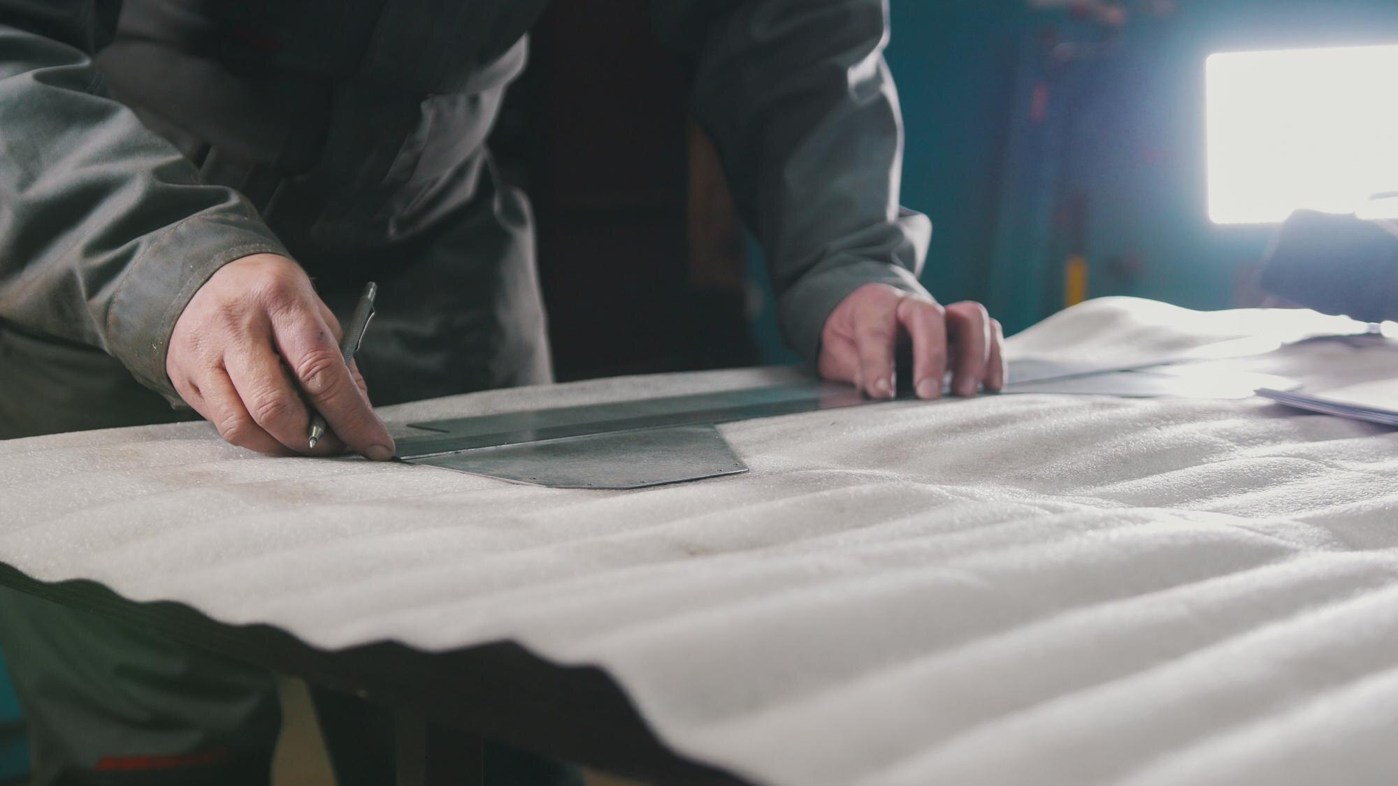 How to choose cut-to-size plastics for damp and cold‑weather jobs 2 worker making measurements and marks on a part by bc3e21eb423eb81e71c1