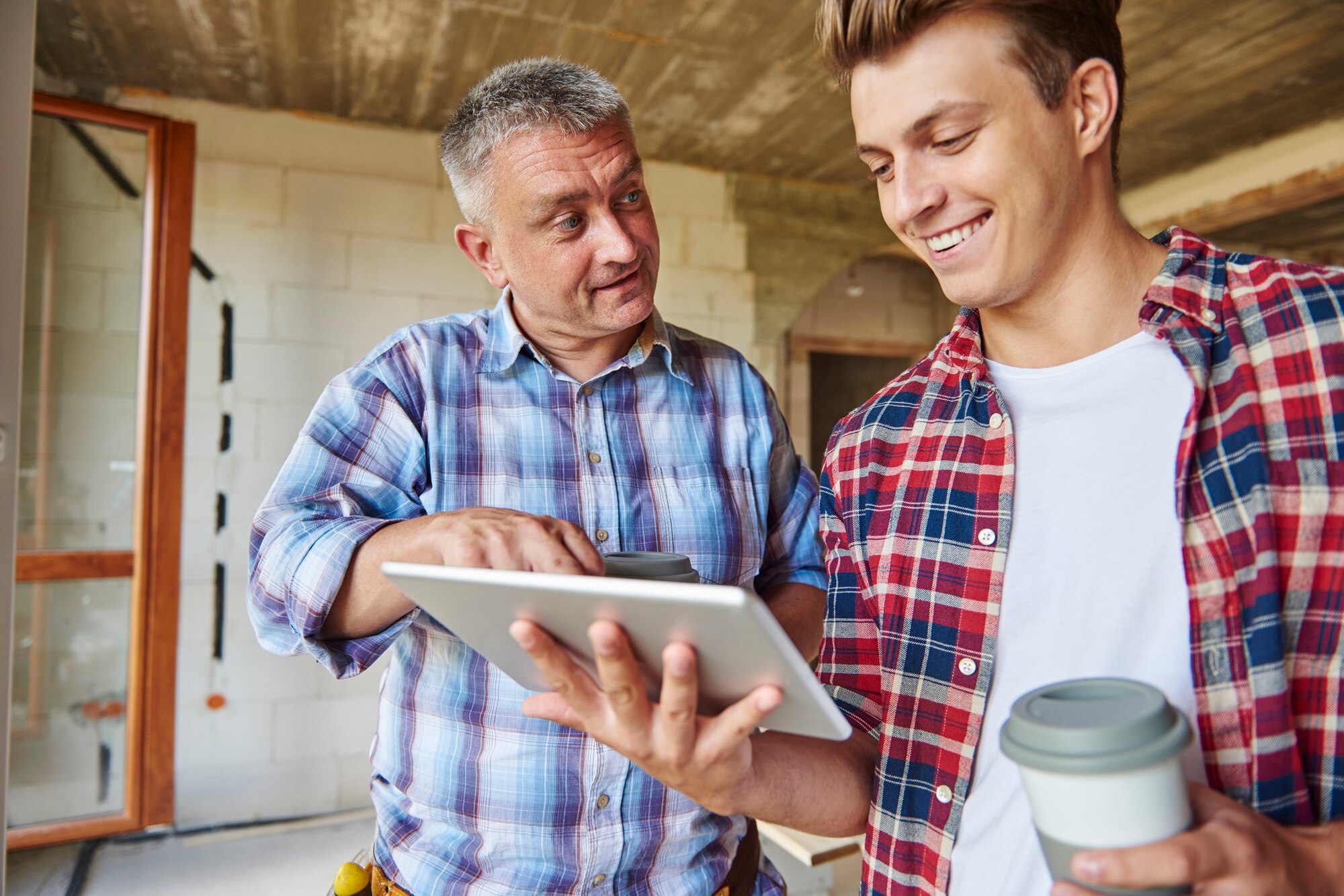 Two workers discussing over a tablet.