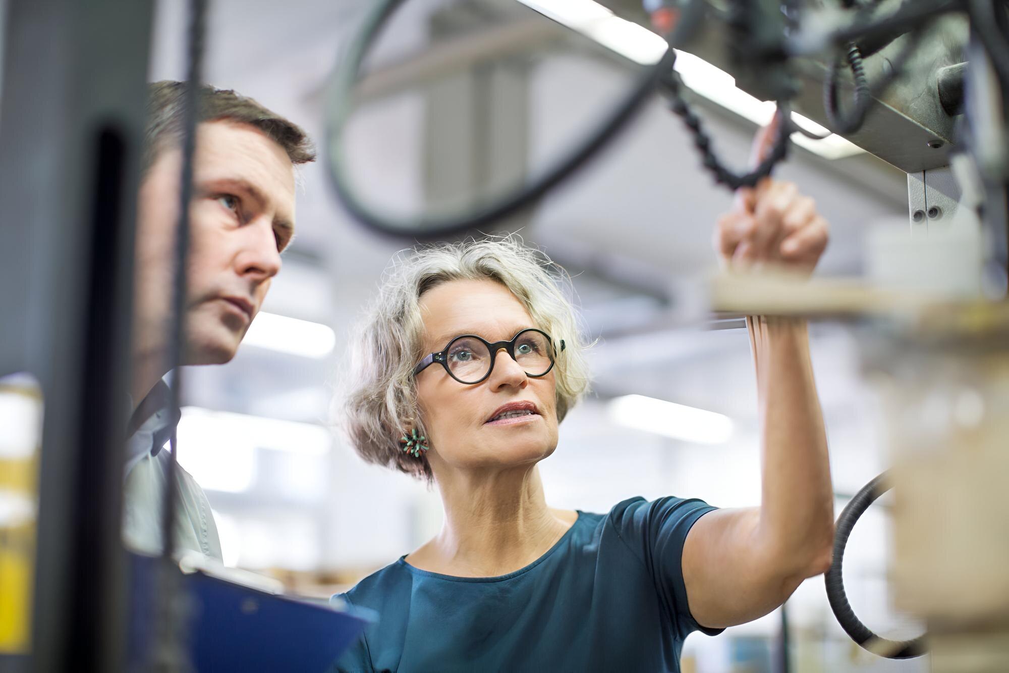 Top Applications of Custom Plastic Fabrication Across Australian Industries 2 workers looking at printing press and discussing f945453479cf4896c349