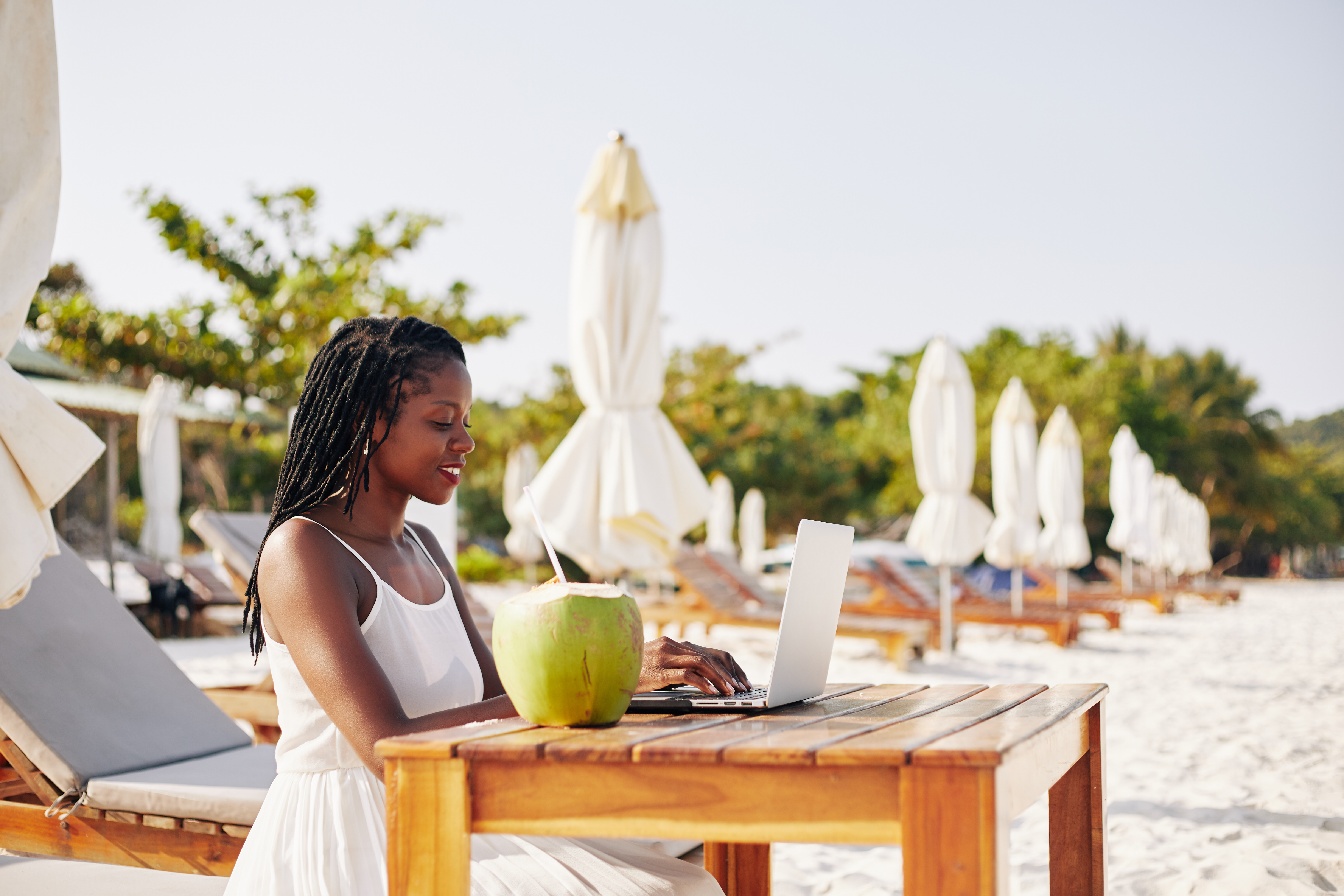 Balancing Wanderlust and Work: Tips for Women Building Travel Careers 3 working at desk on sandy beach b9f3f97c530c5c829084