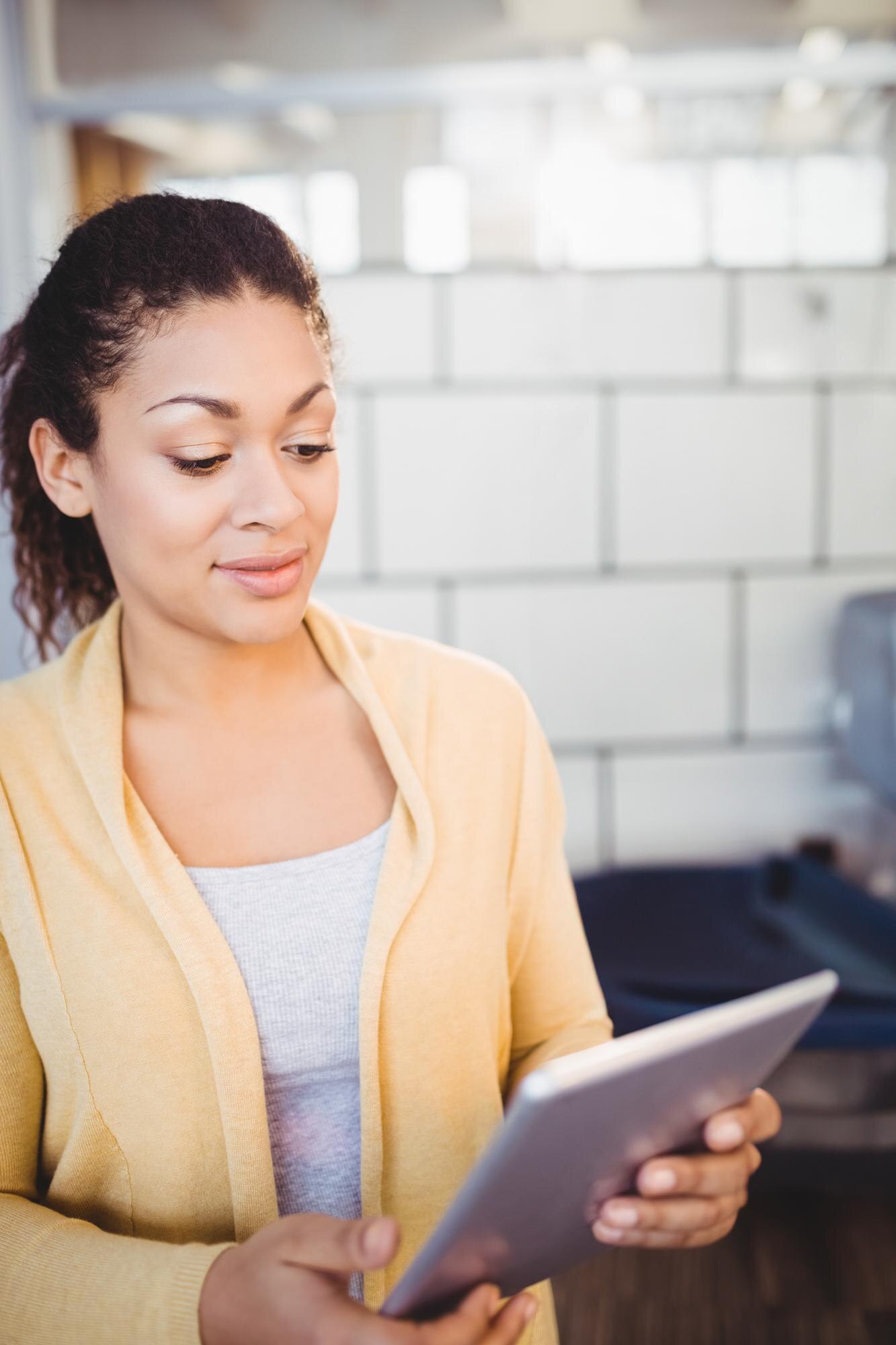 young african american woman holding tablet device 40790b7de4658b1e2eb4