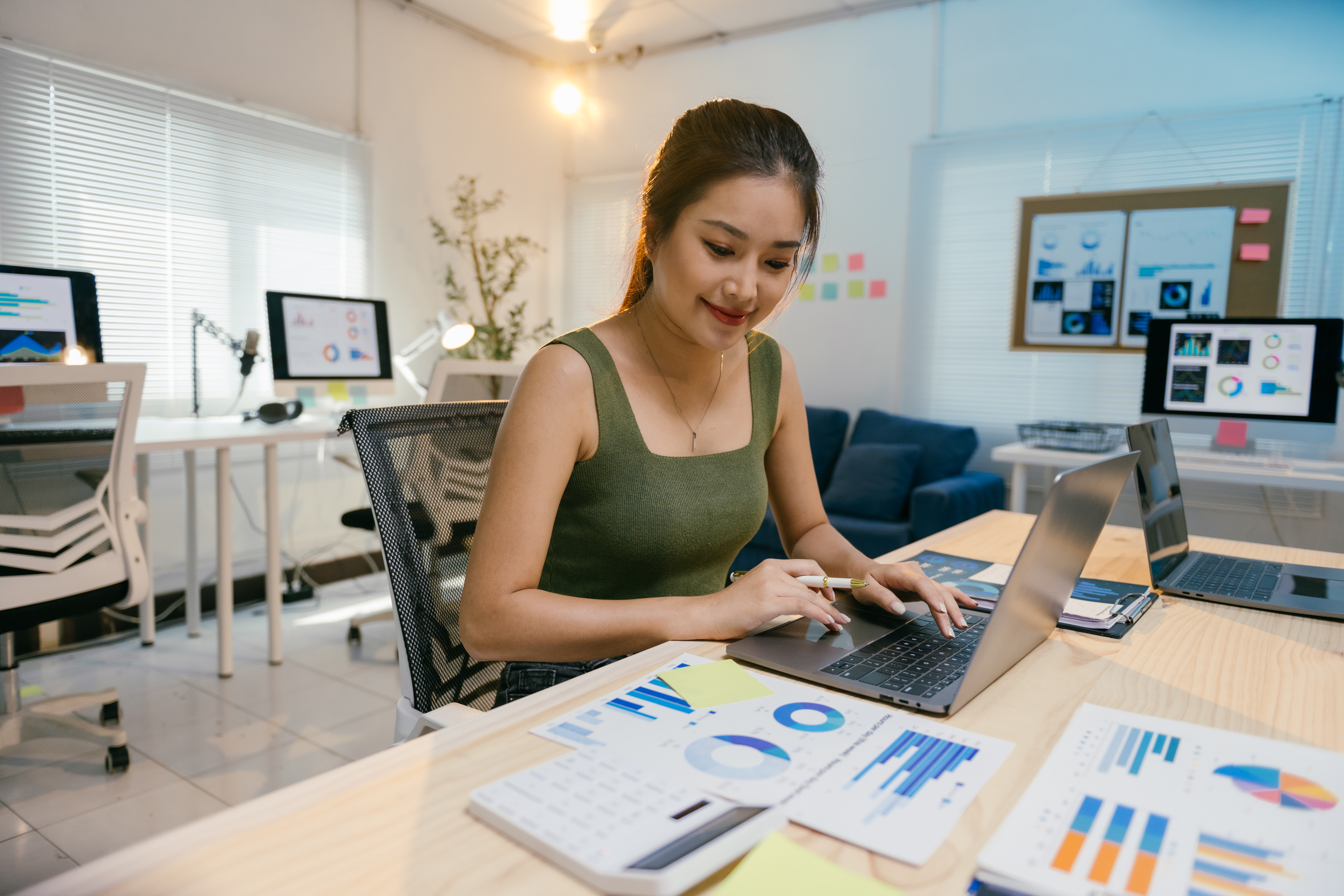 Asian businesswoman analyzing data on laptop for social media marketing solutions