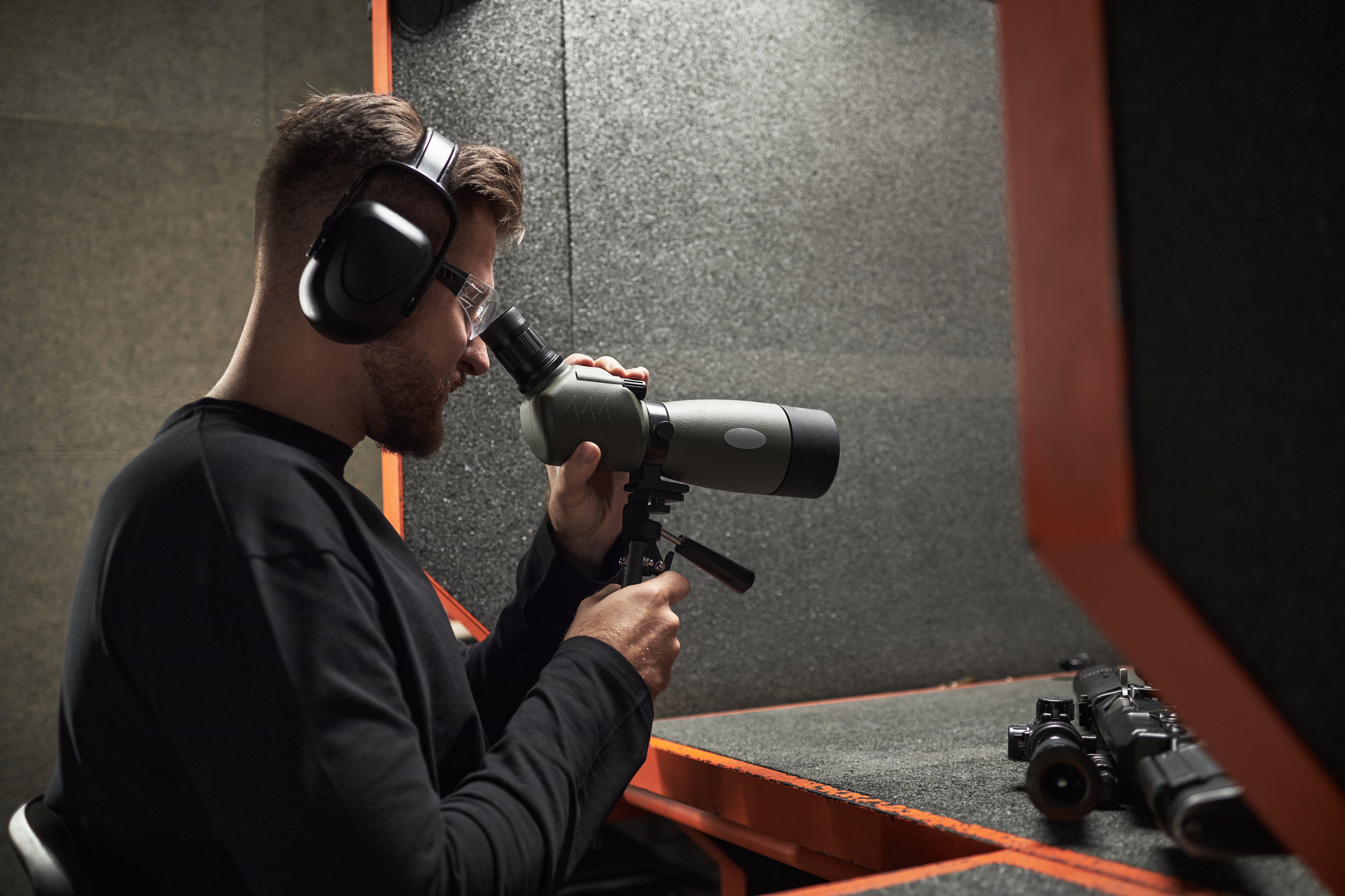 young caucasian man observing target through spott a80acbc64f7ed465e732
