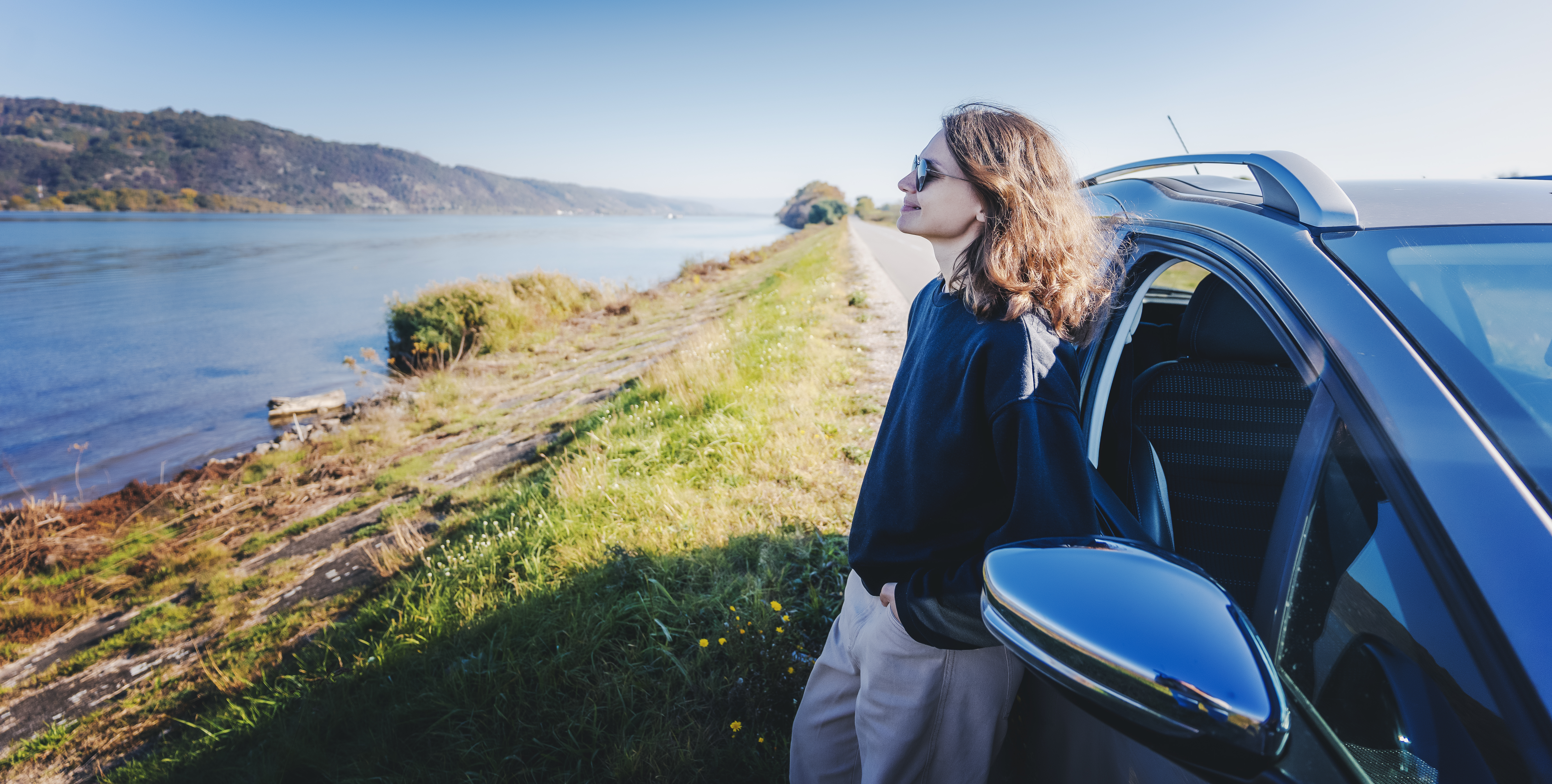 young cheerful woman traveler standing next to car e961f20b72ba823fb552 BTOURS
