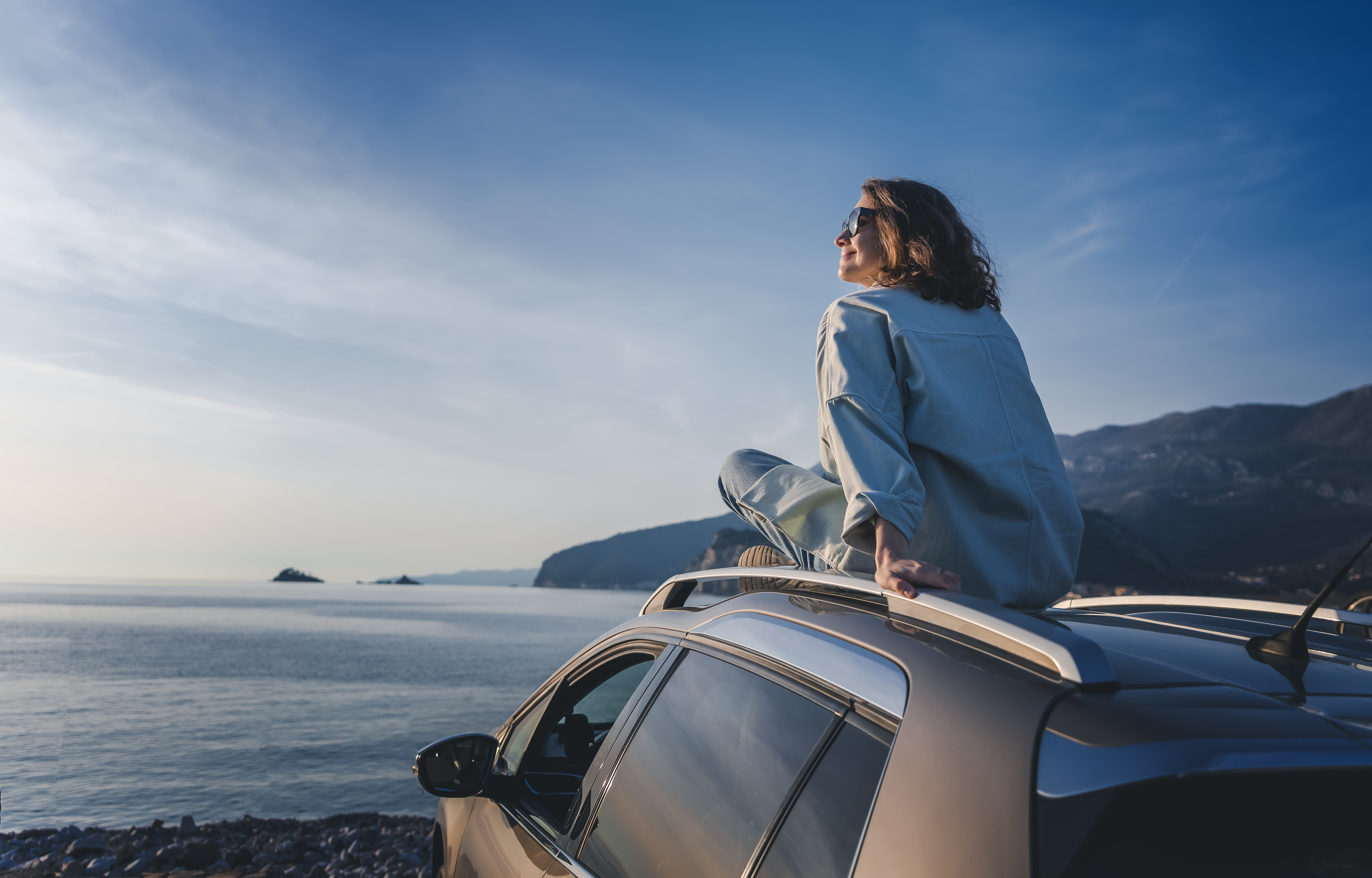 young happy woman traveler sitting on car roof enj 08b1d72e7786e9a1fd2e BTOURS